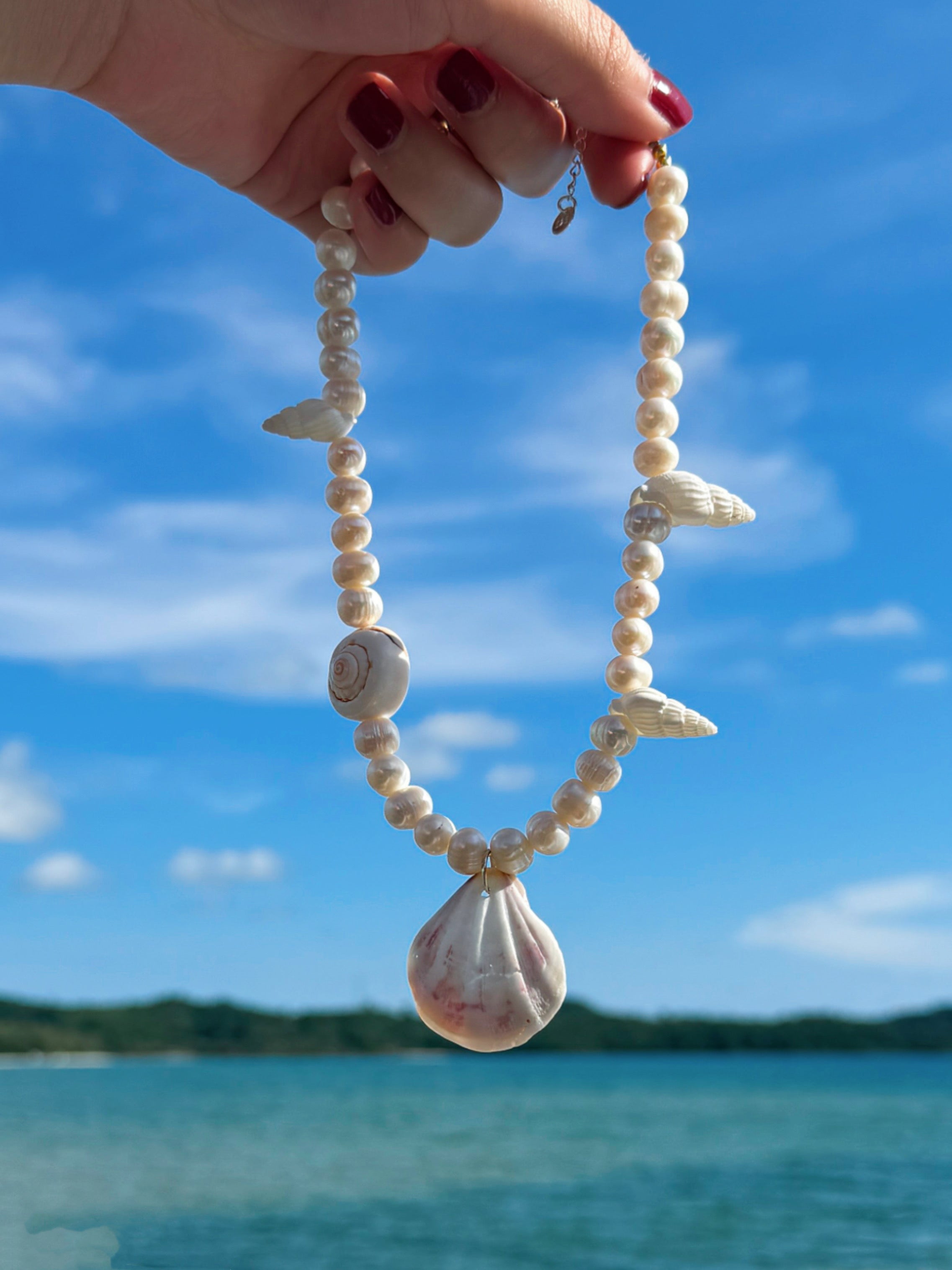 Model wearing the handmade Statement Seashell Pearl Choker, featuring natural freshwater pearls, real seashells, and tribal silver closure—styled as coastal boho jewelry, perfect for beach weddings, honeymoons, and resort wear.