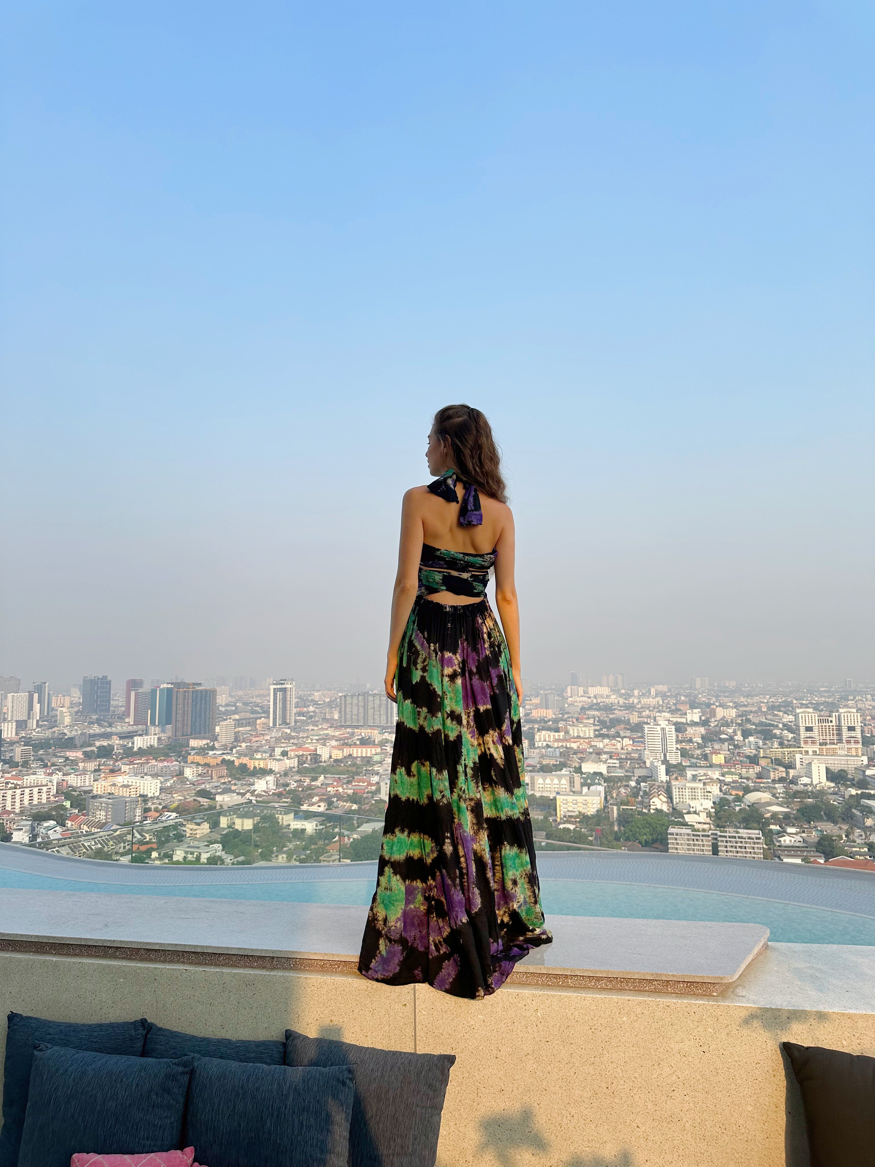 The Butterfly Infinity Maxi Dress Tie Dye is a limited edition piece featuring a maxi-length skirt and captivating hand-tie-dye pattern inspired by butterflies and vacation vibes. The dress is shown in a stylish and versatile design, suitable for transitioning seamlessly from day to night. With the Infinity Dress, you can explore different looks for any occasion. This lightweight and comfortable dress flatters all body types, making it perfect for bohemian style or resort wear.