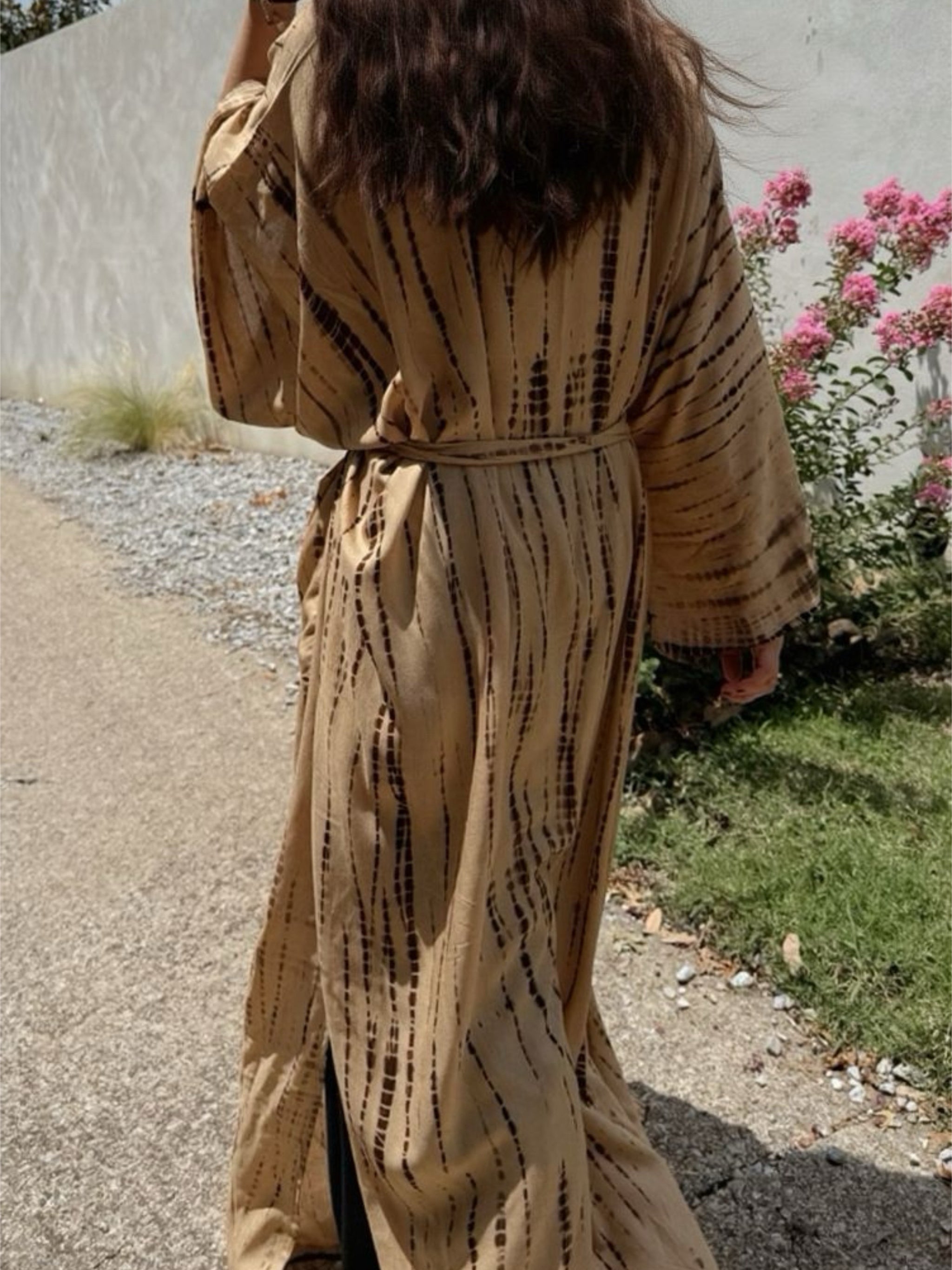 Woman wearing a tan tie-dye long kimono robe from Coco de Chom. The oversized robe features long sleeves, a waist tie, and a relaxed, boho-style fit.
