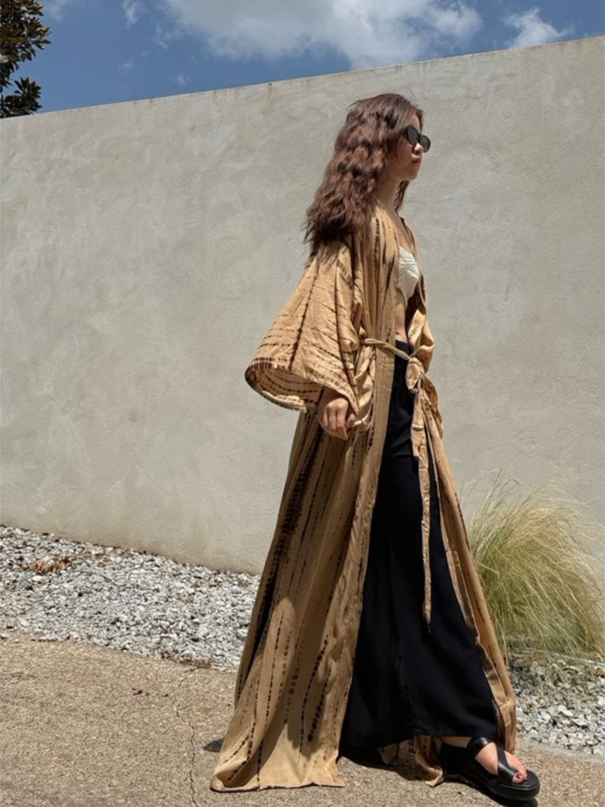 Woman wearing a tan tie-dye long kimono robe from Coco de Chom. The oversized robe features long sleeves, a waist tie, and a relaxed, boho-style fit.