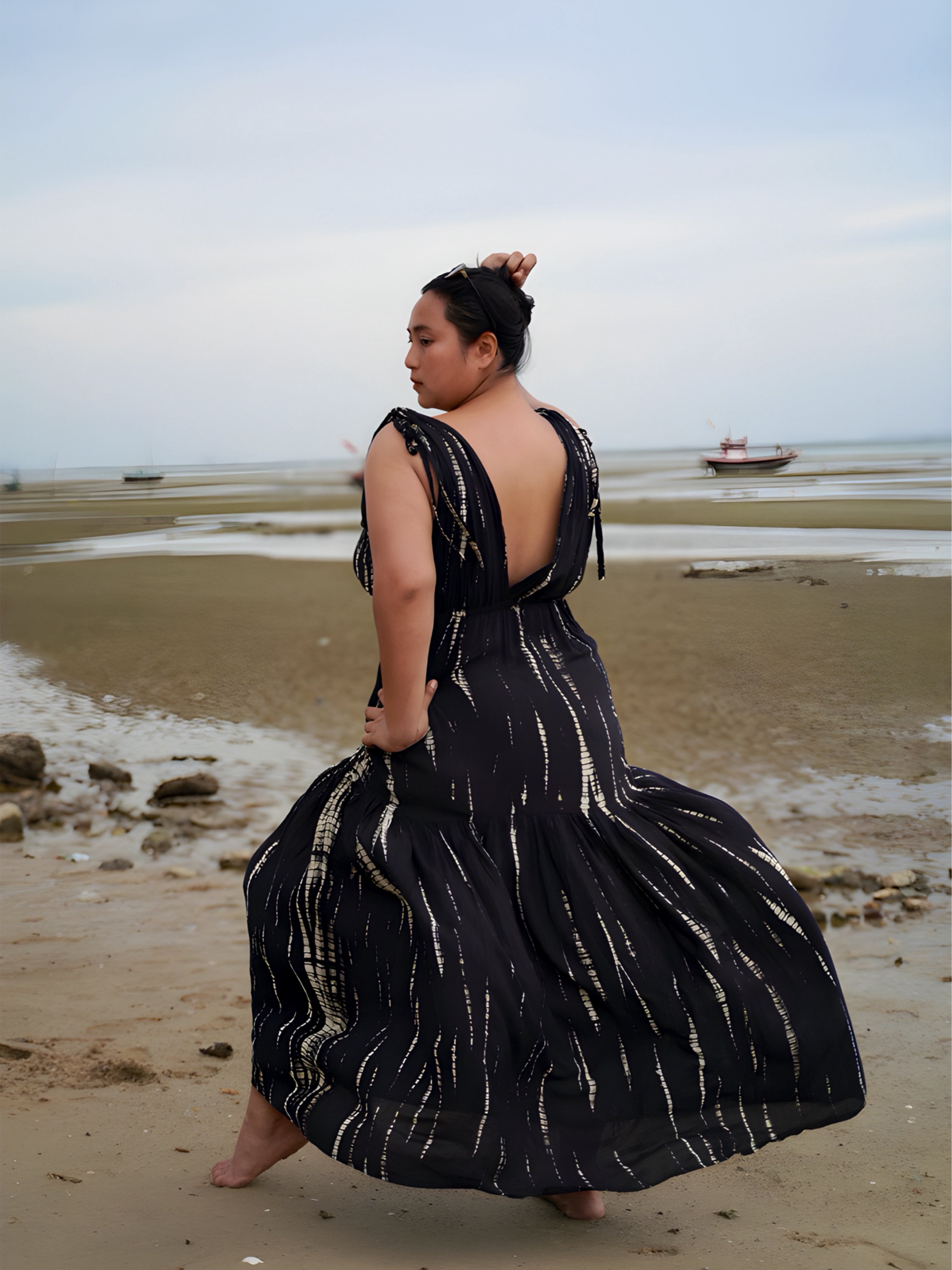 Model wearing a flowy, black tie-dye goddess kaftan dress with deep V-neckline and ruffled hem, handcrafted from soft rayon. Oversized boho kaftan designed for beachwear, resort lounging, or stylish everyday wear.