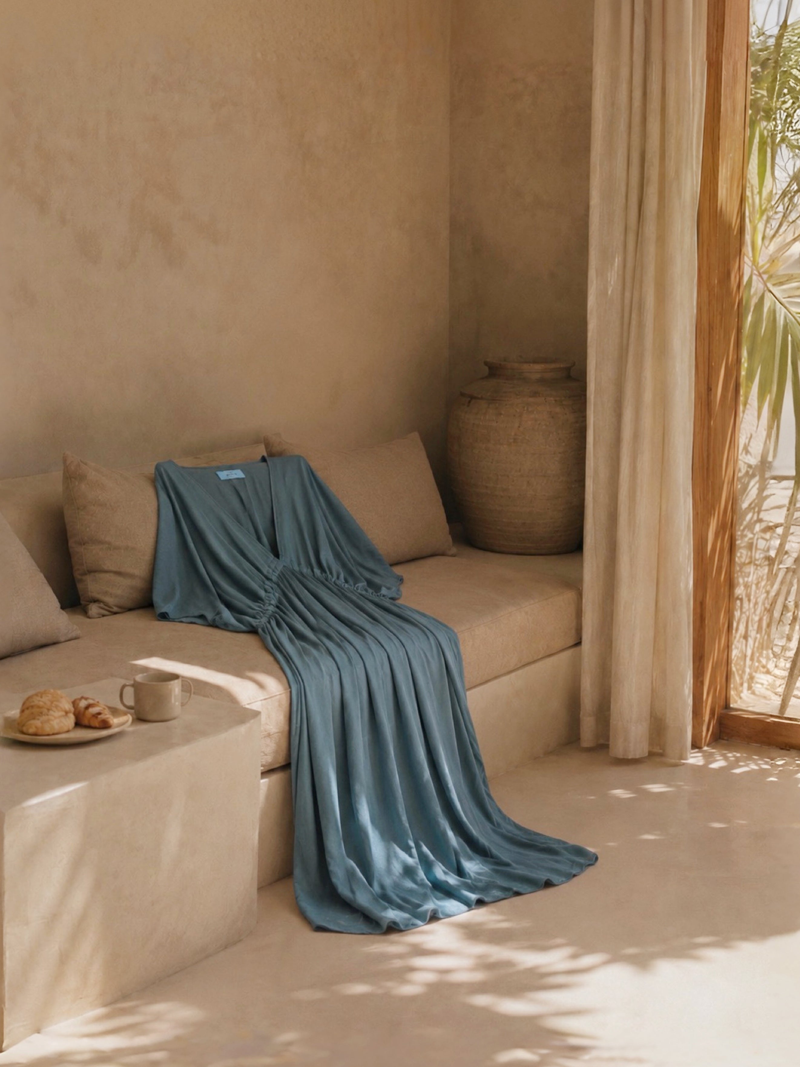Teal kaftan dress styled as a long caftan dress for elevated resort wear, worn barefoot in a tropical oceanfront villa with breezy vacation style.