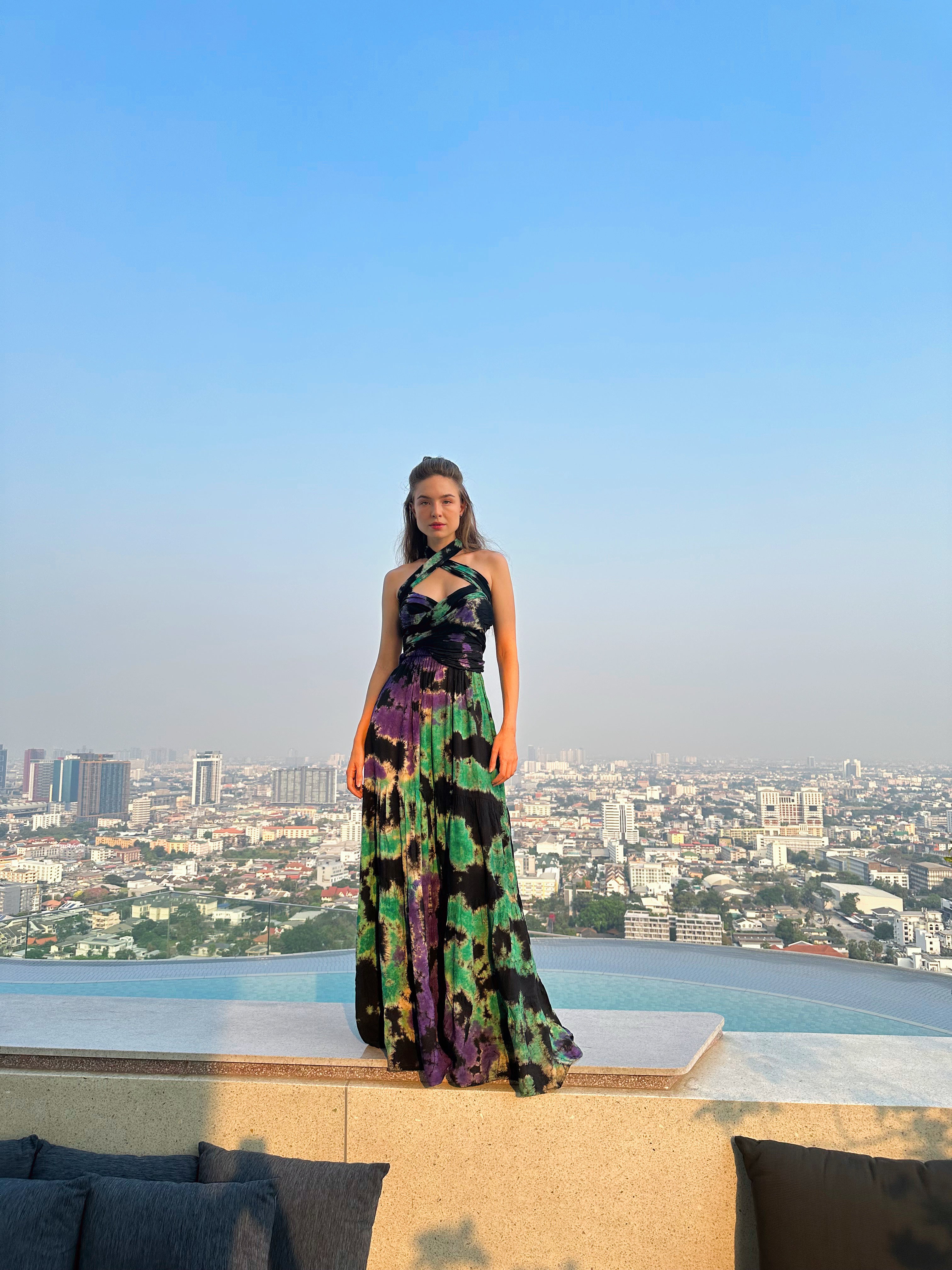 The Butterfly Infinity Maxi Dress Tie Dye is a limited edition piece featuring a maxi-length skirt and captivating hand-tie-dye pattern inspired by butterflies and vacation vibes. The dress is shown in a stylish and versatile design, suitable for transitioning seamlessly from day to night. With the Infinity Dress, you can explore different looks for any occasion. This lightweight and comfortable dress flatters all body types, making it perfect for bohemian style or resort wear.