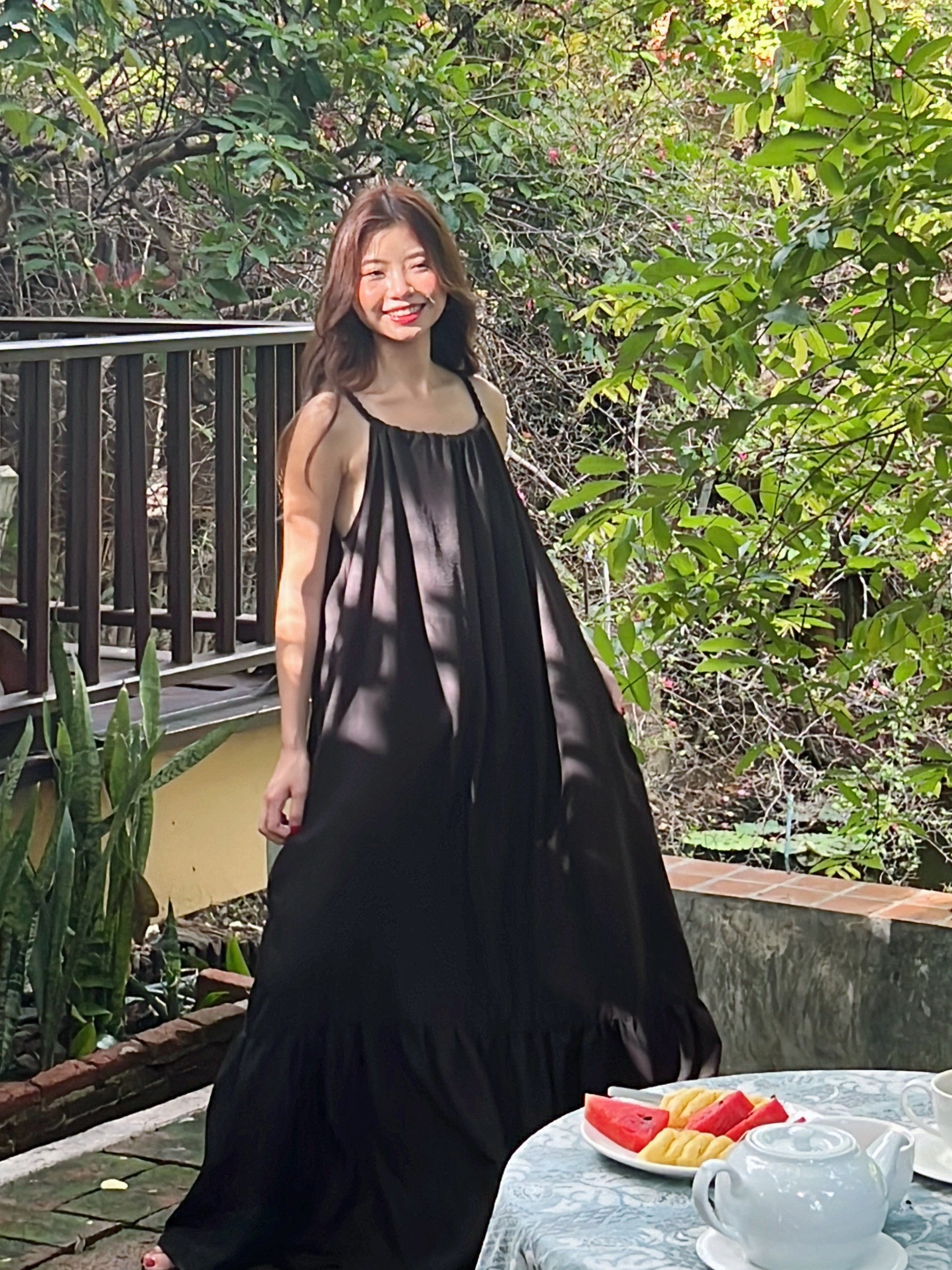 Model wearing Olivia Open Back Maxi Dress with adjustable rope straps and ruffles — perfect vacation outfit.