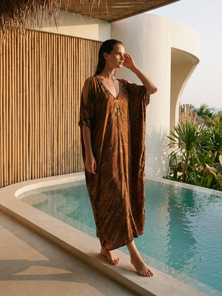 Woman wearing a brown zebra tie dye V neck kaftan dress with oversized flowy silhouette and cold shoulder detail