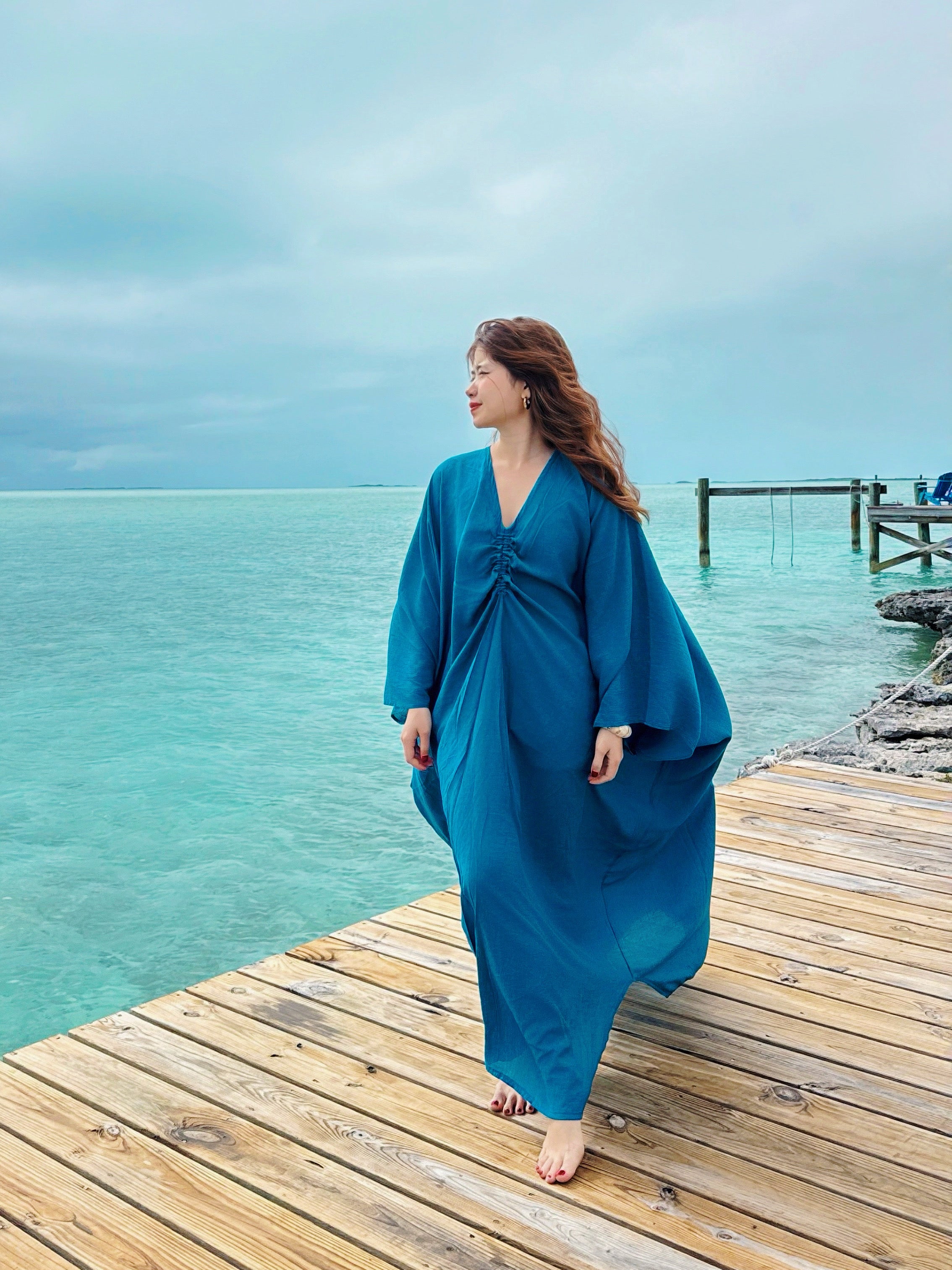 Woman wearing a teal blue Kaftan maxi dress, resort caftan maxi dress, beach cover up with relaxed sleeves and elegant drape—perfect for pool, beach, and cruise