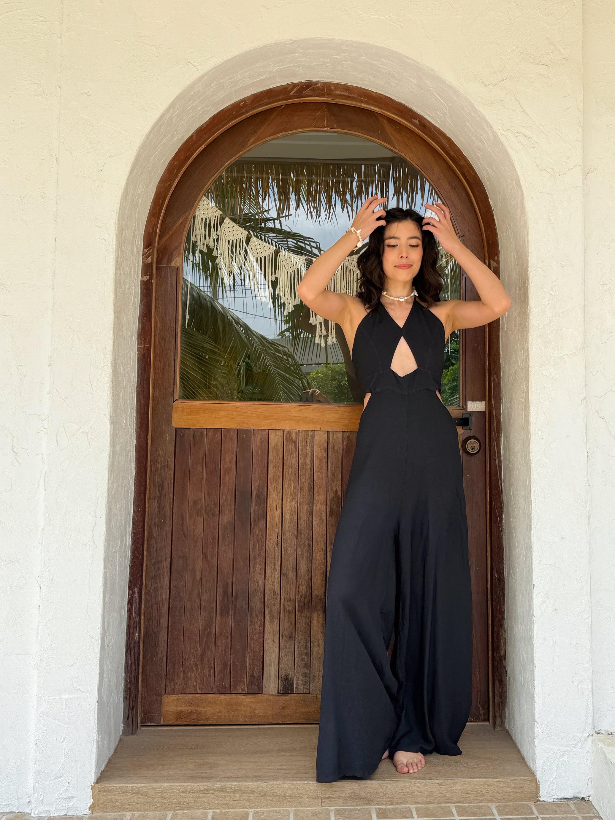 Front view of model in hand-dyed boho cut-out jumpsuit with wide legs and visible pockets—resort summer outfit.