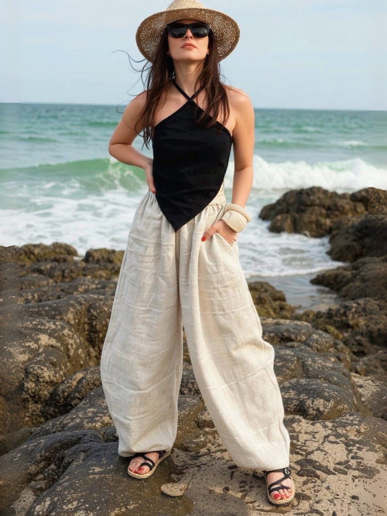 Woman wearing barrel cut linen pants on beach vacation – lightweight wide-leg trousers styled for effortless travel and summer comfort
