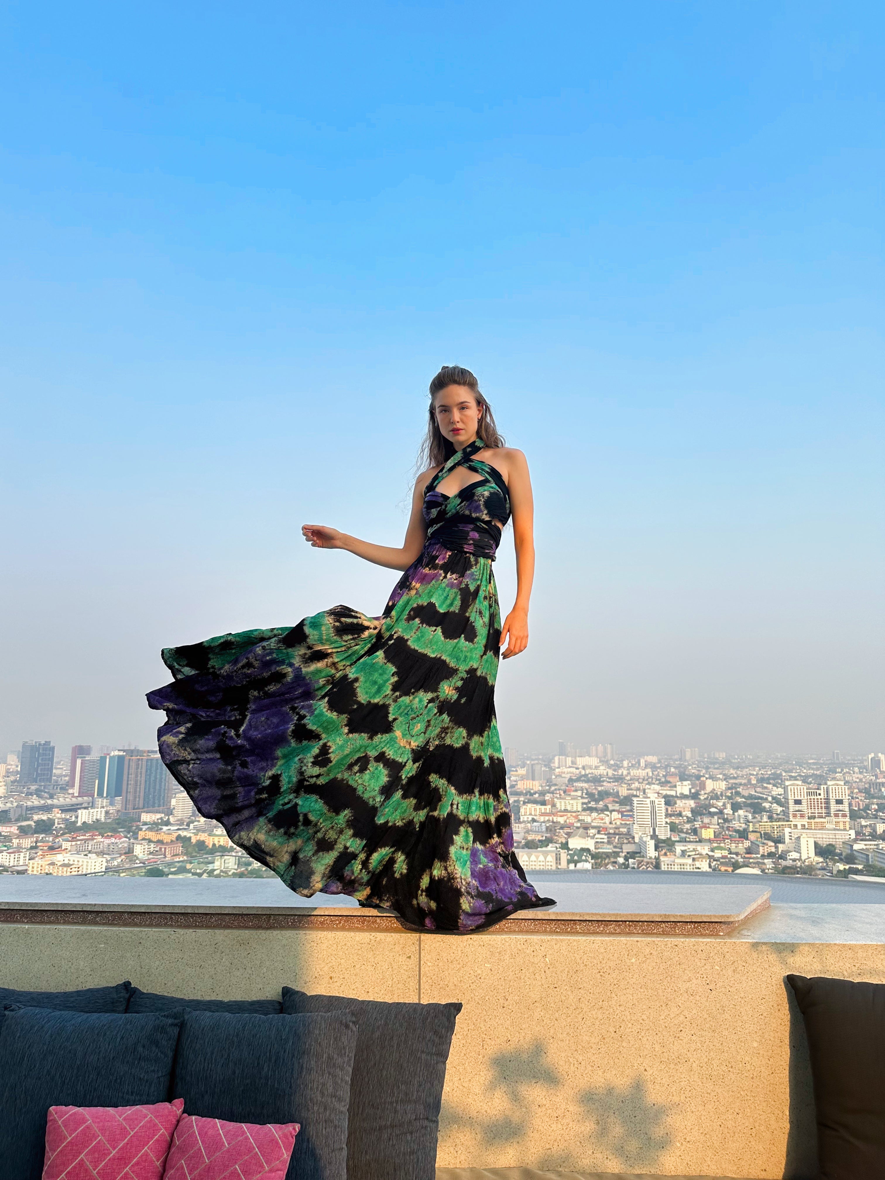 The Butterfly Infinity Maxi Dress Tie Dye is a limited edition piece featuring a maxi-length skirt and captivating hand-tie-dye pattern inspired by butterflies and vacation vibes. The dress is shown in a stylish and versatile design, suitable for transitioning seamlessly from day to night. With the Infinity Dress, you can explore different looks for any occasion. This lightweight and comfortable dress flatters all body types, making it perfect for bohemian style or resort wear.