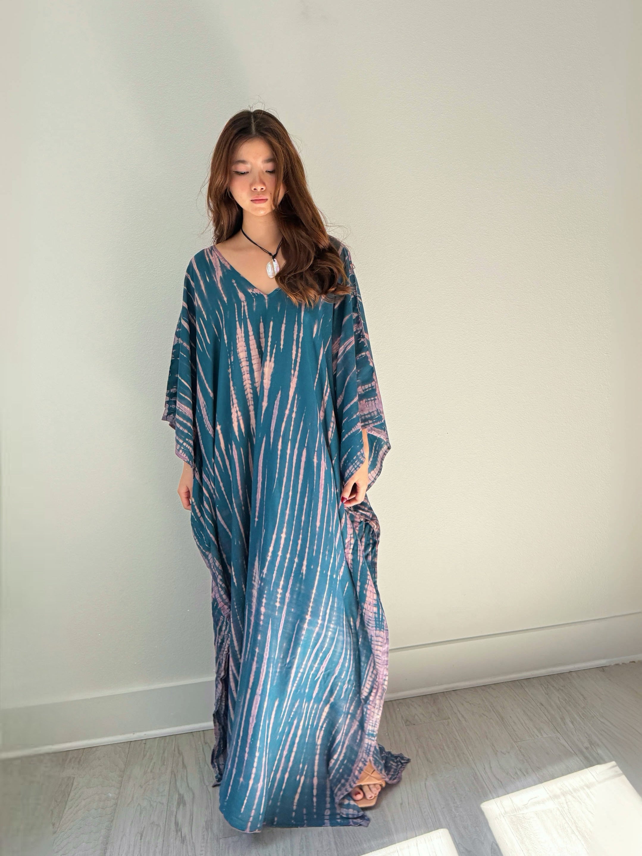 Model wearing a teal tie-dye boho caftan dress; long handmade kaftan perfect as a beach cover-up, vacation kaftan, or oversized resort wear for women. Ideal gift for her and great for lounging or bohemian beachwear style.