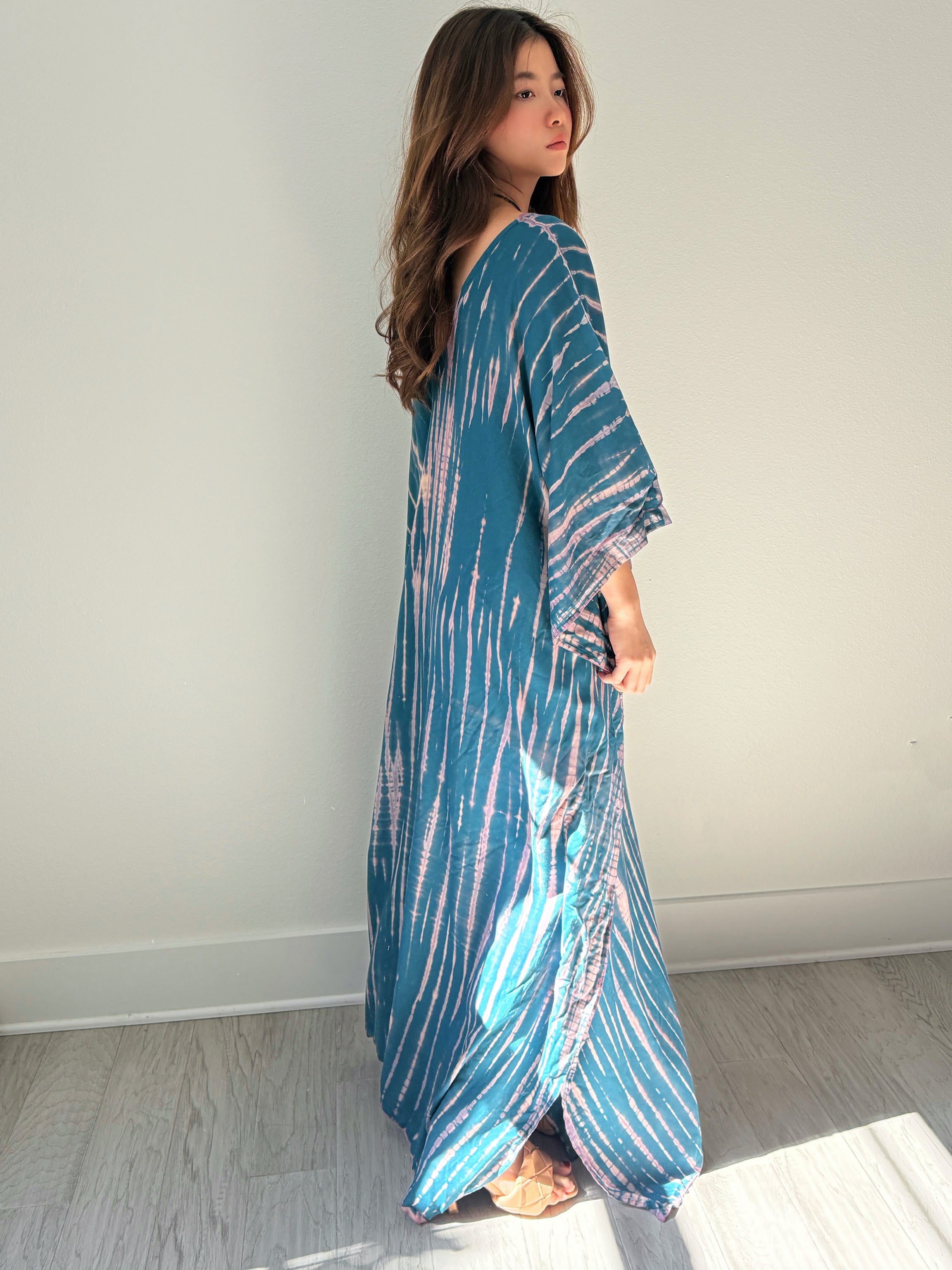 Model wearing a teal tie-dye boho caftan dress; long handmade kaftan perfect as a beach cover-up, vacation kaftan, or oversized resort wear for women. Ideal gift for her and great for lounging or bohemian beachwear style.