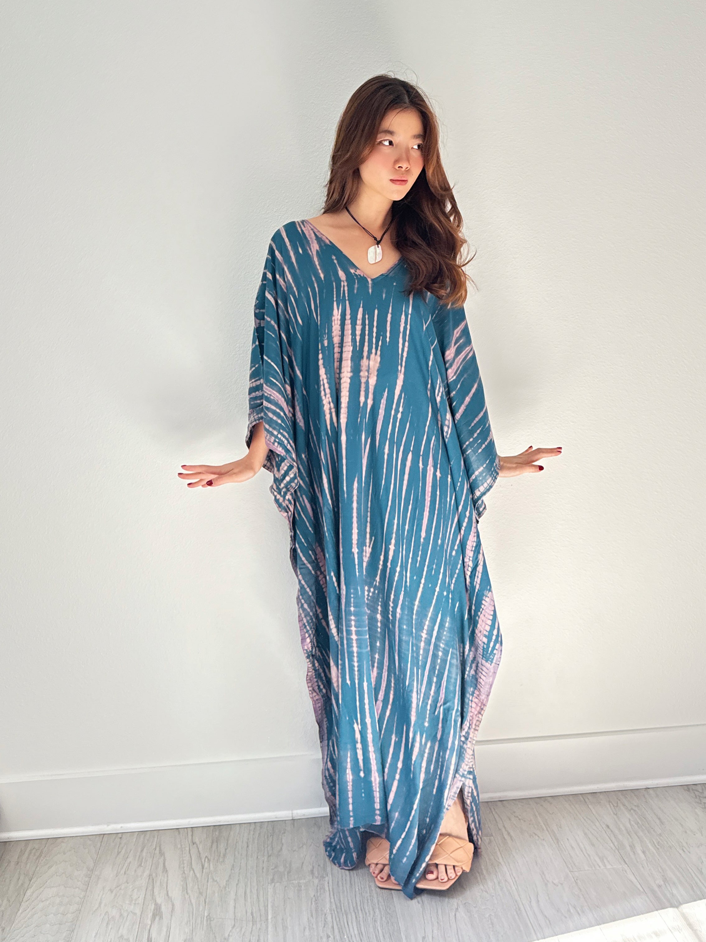 Model wearing a teal tie-dye boho caftan dress; long handmade kaftan perfect as a beach cover-up, vacation kaftan, or oversized resort wear for women. Ideal gift for her and great for lounging or bohemian beachwear style.