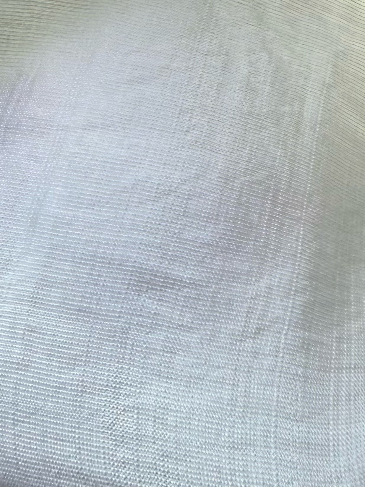 A close-up of a light gray woven fabric texture with a fine, ribbed pattern.
