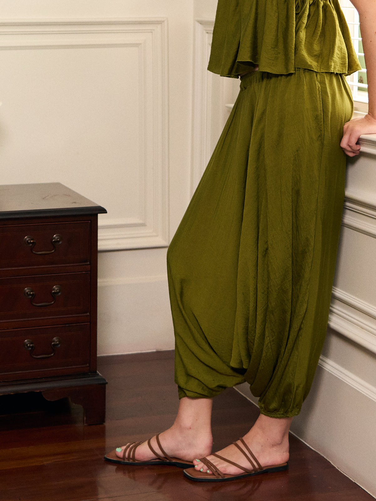 Close-up of Mira olive green harem pants showing the flowing drape and gathered elastic cuffs