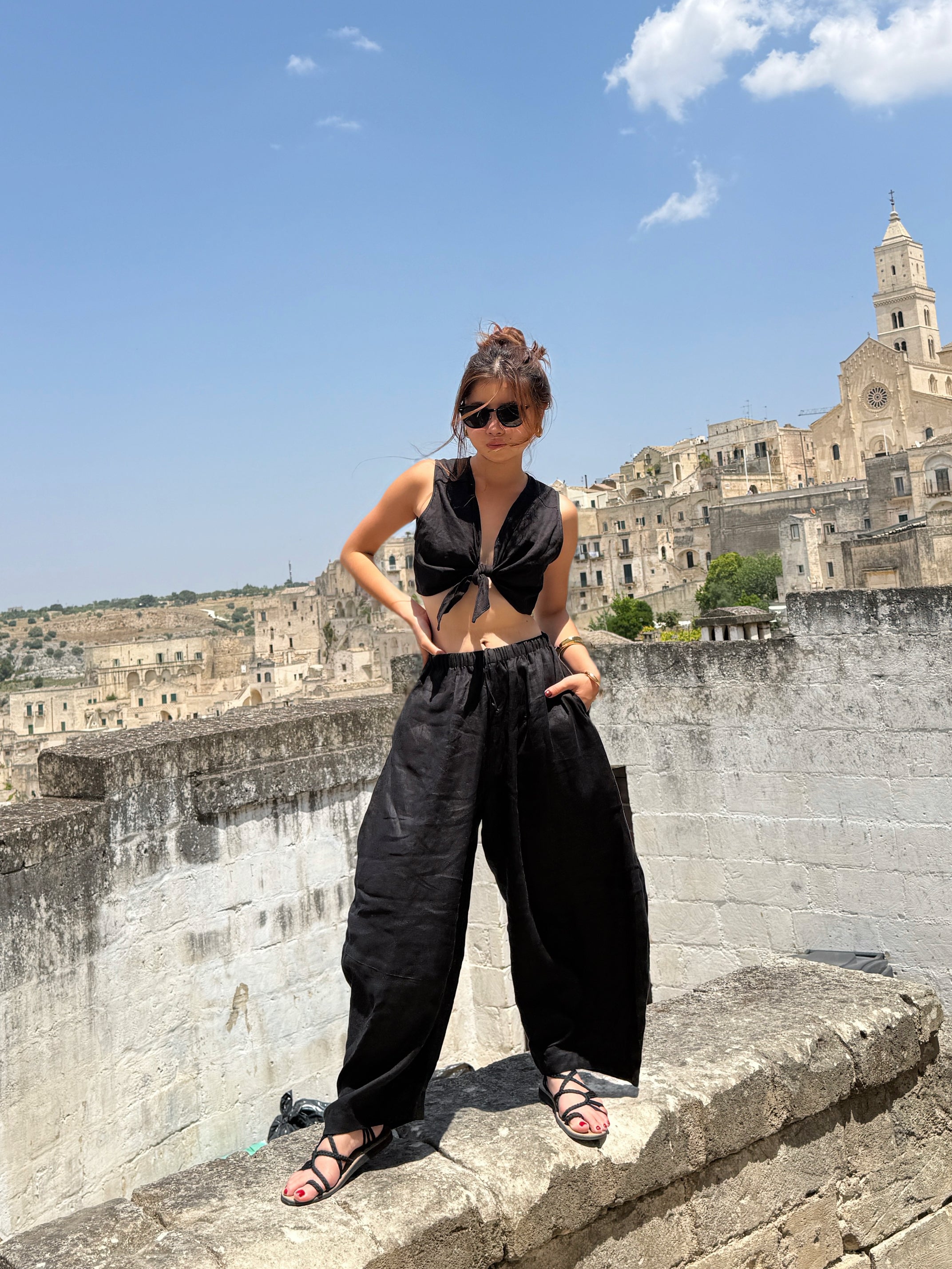 Model wearing flowing black linen wide-leg pants in barrel cut – breathable, handmade boho trousers for women, perfect for summer and travel