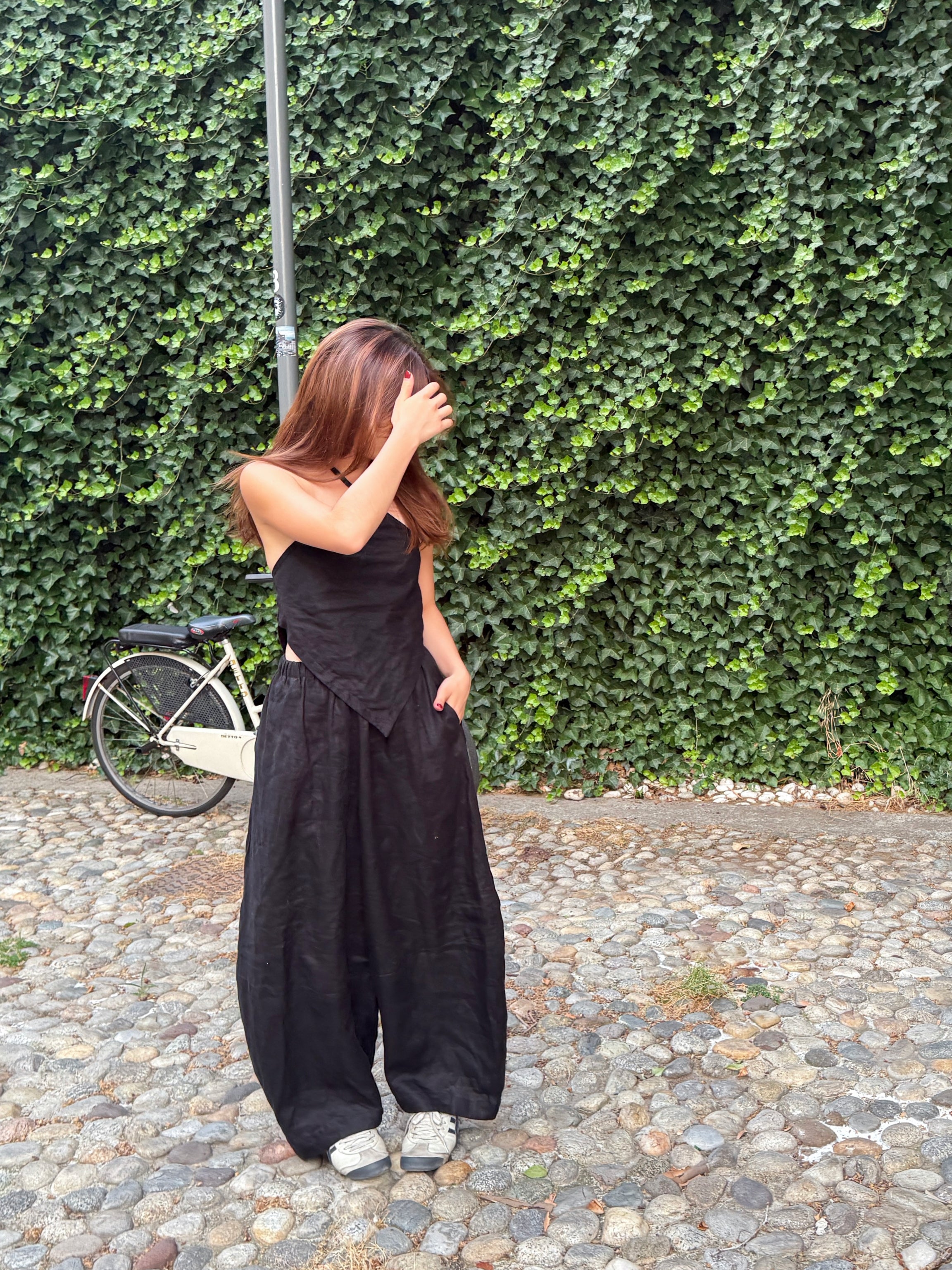 Model wearing flowing black linen wide-leg pants in barrel cut – breathable, handmade boho trousers for women, perfect for summer and travel