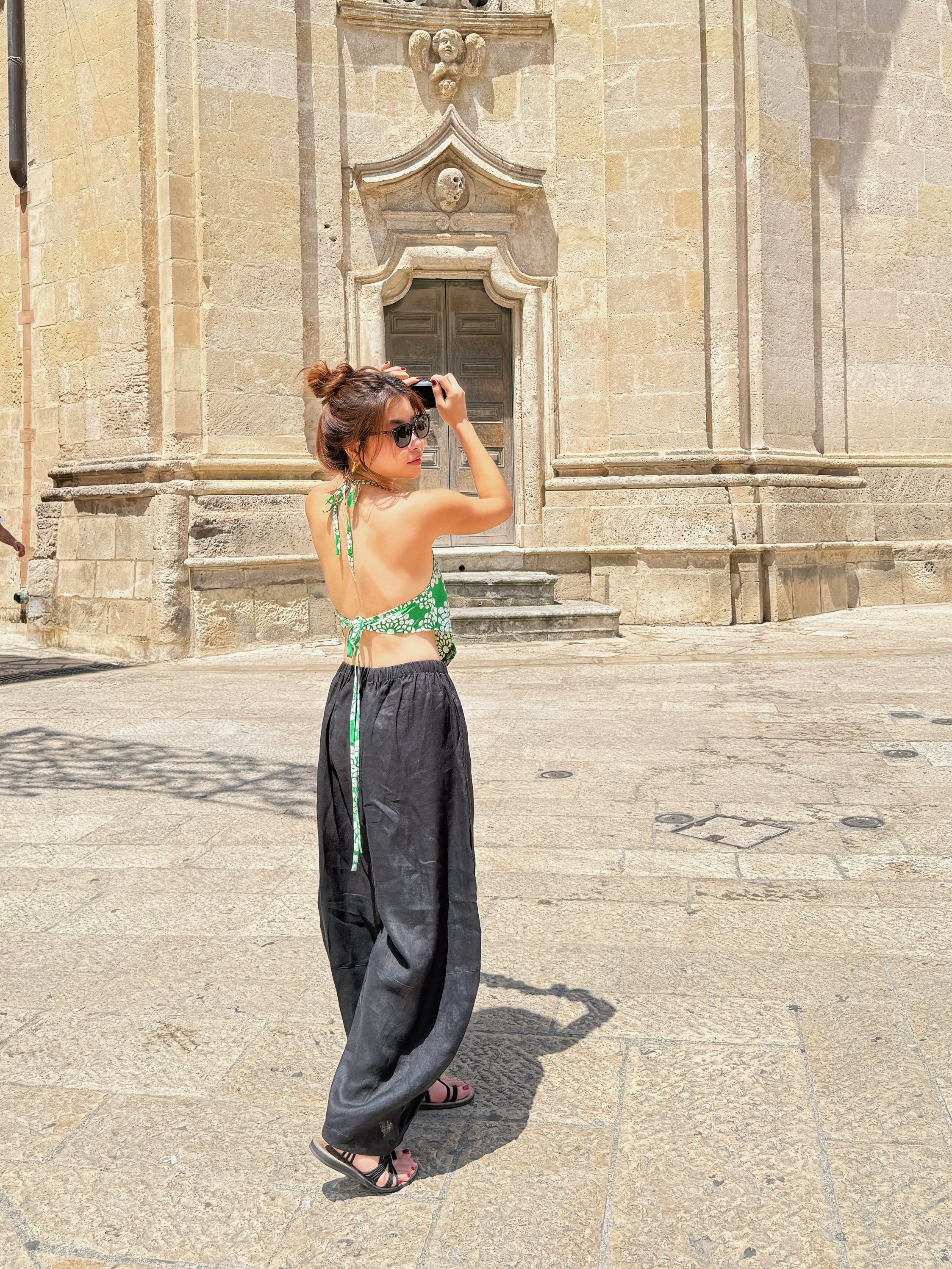 Model wearing flowing black linen wide-leg pants in barrel cut – breathable, handmade boho trousers for women, perfect for summer and travel