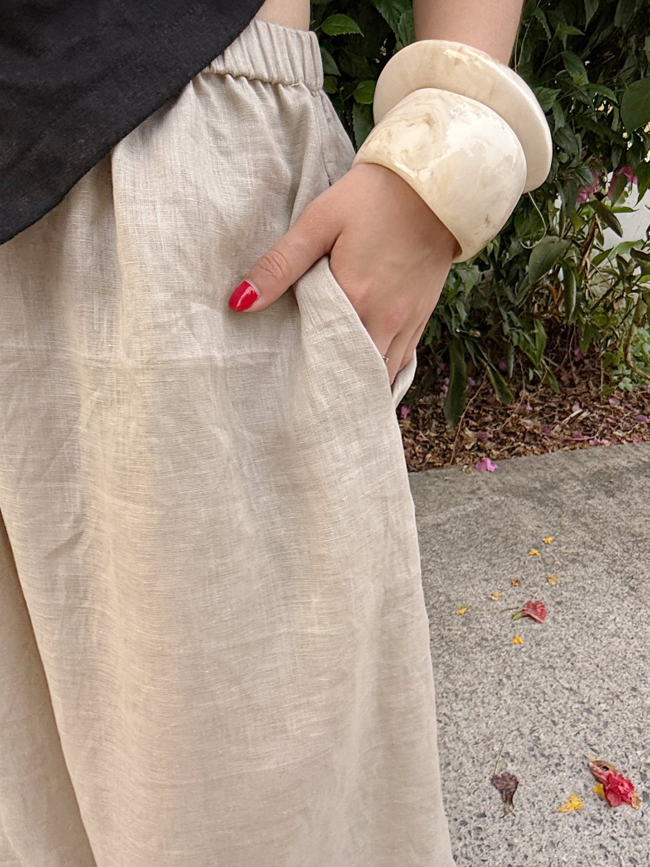 Flowing linen wide-leg pants in barrel cut, folded to show fabric texture and shape – handmade resortwear for warm weather
