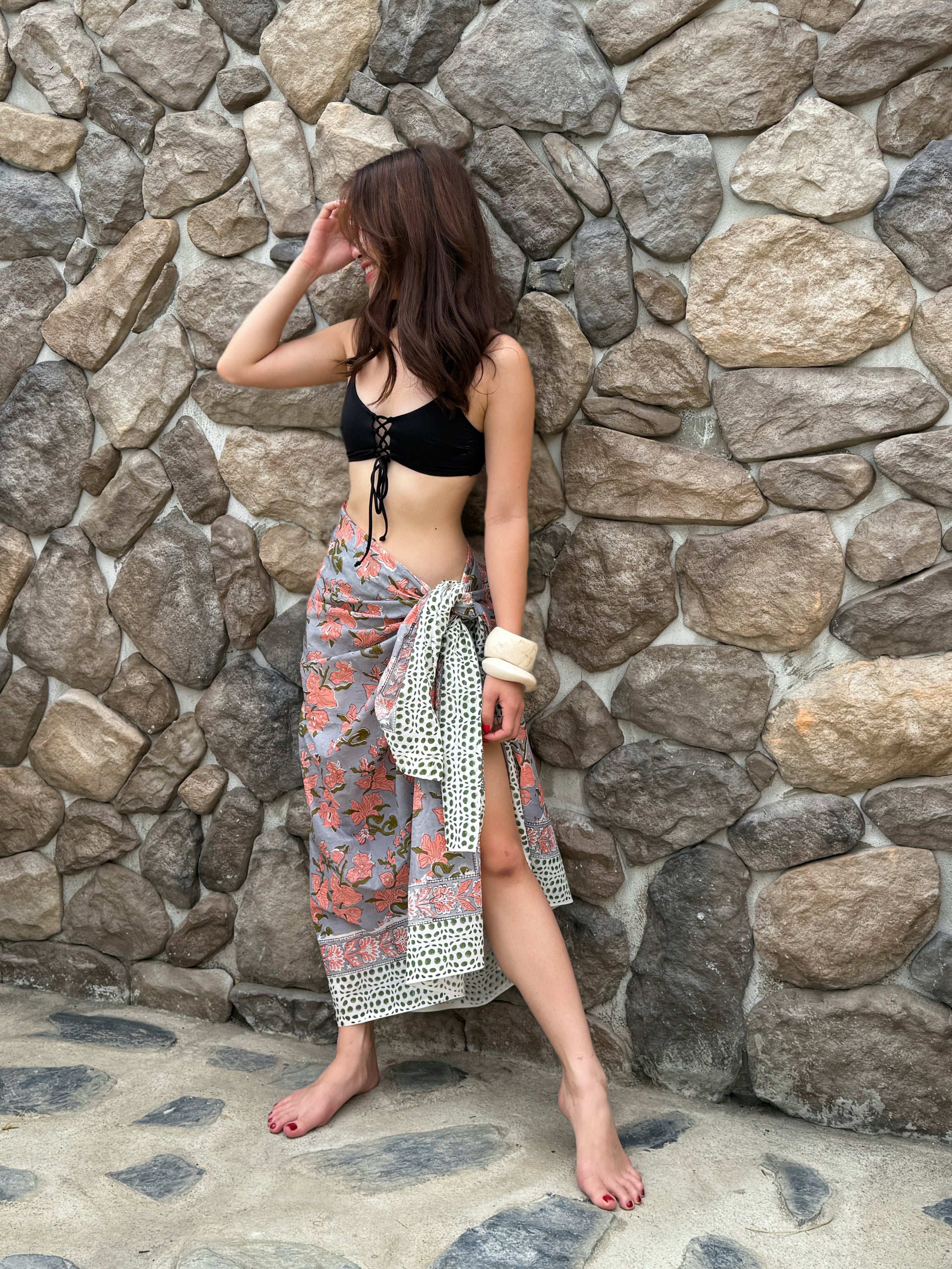 Bohemian beach outfit with floral cotton sarong tied around waist – ethical fashion for summer getaways.