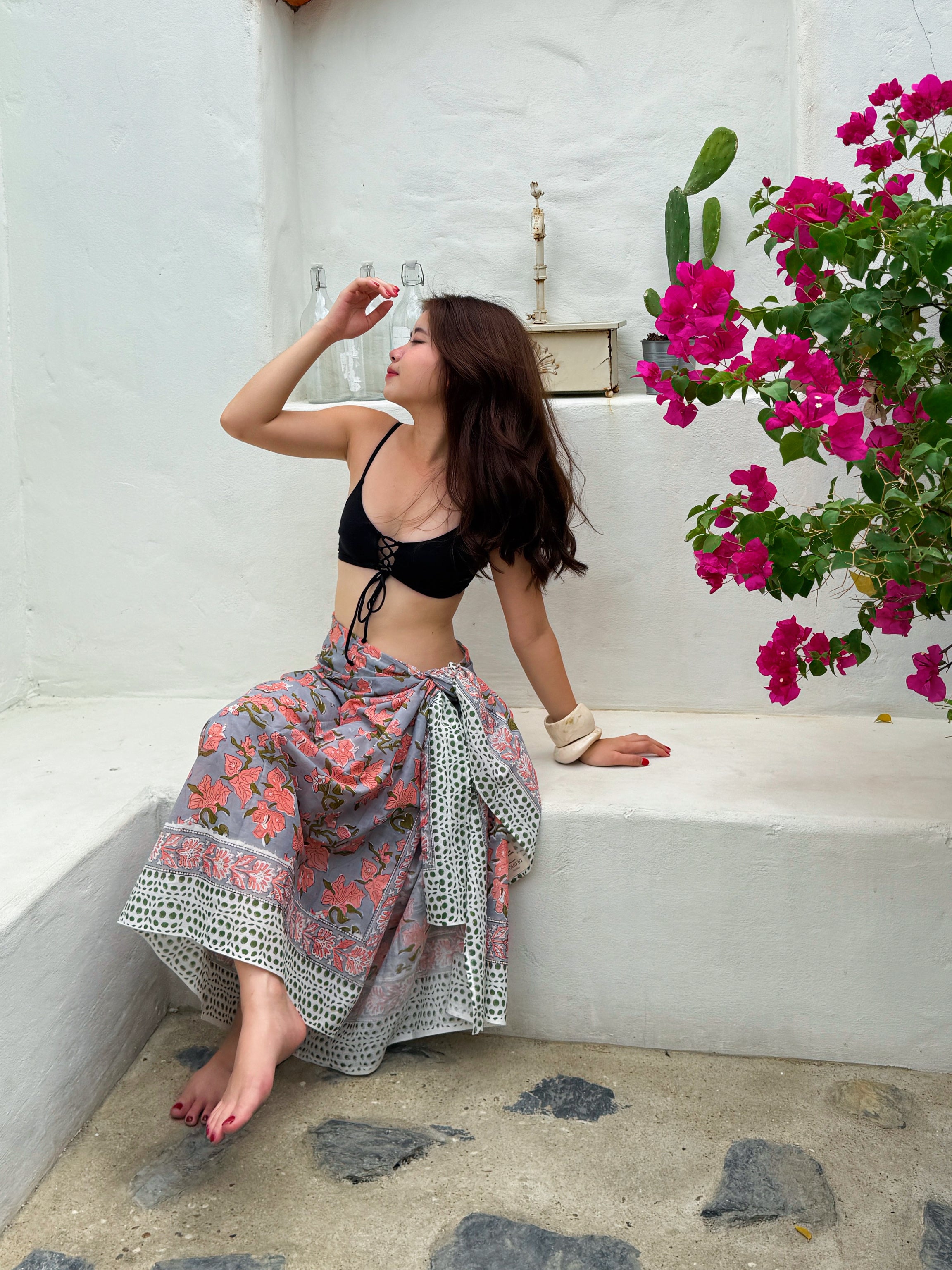Bohemian beach outfit with floral cotton sarong tied around waist – ethical fashion for summer getaways.