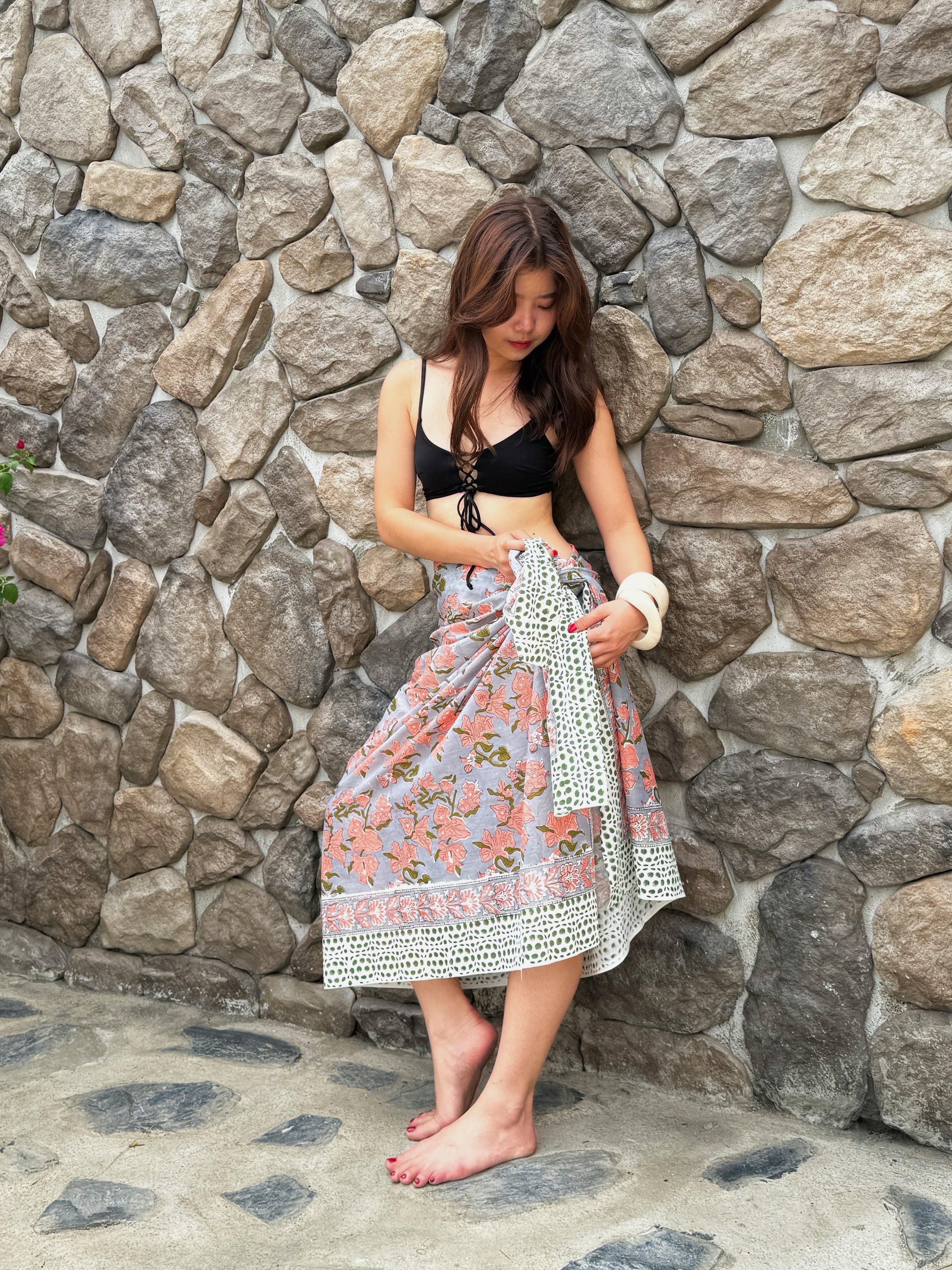 Bohemian beach outfit with floral cotton sarong tied around waist – ethical fashion for summer getaways.