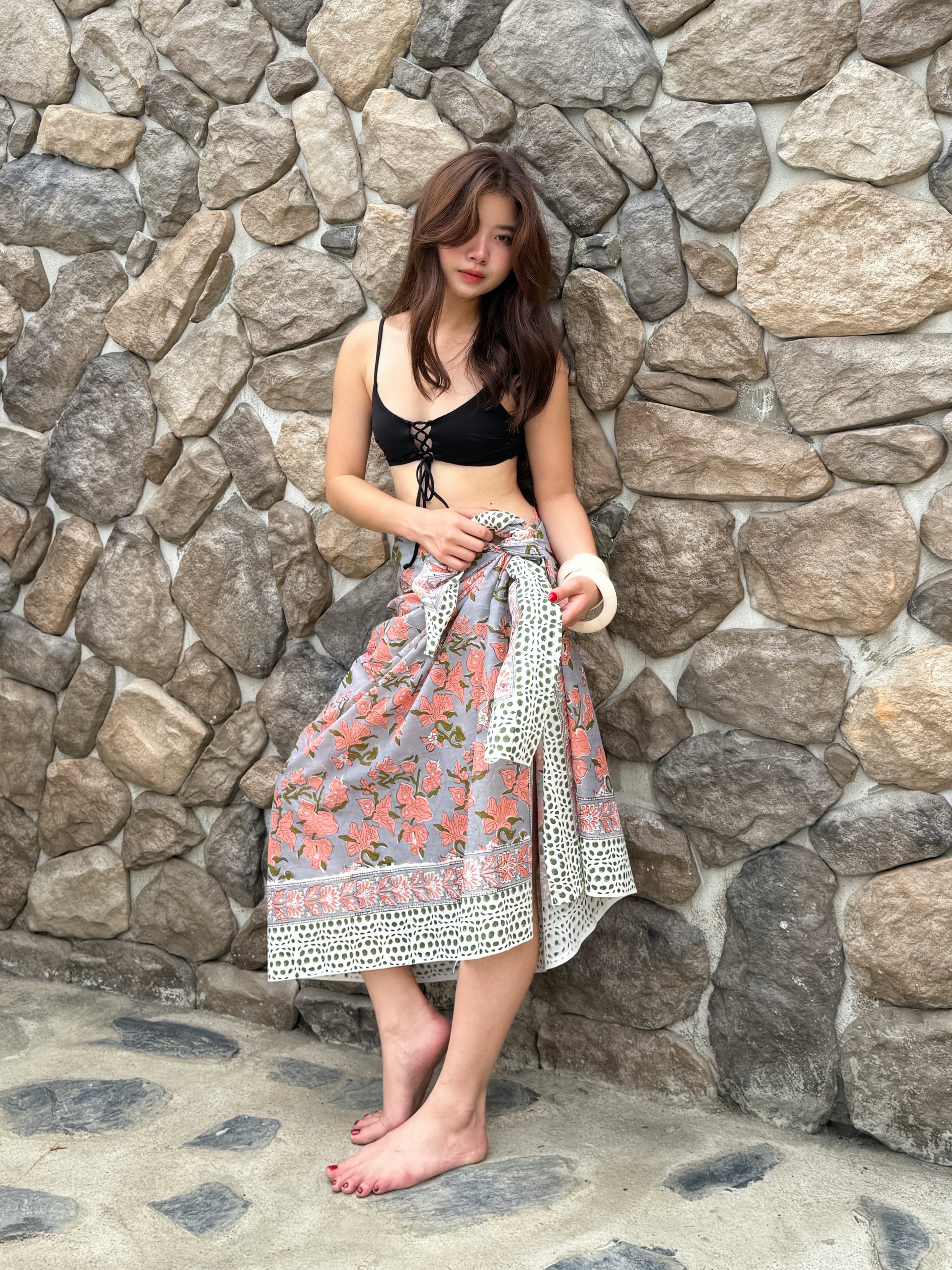 Bohemian beach outfit with floral cotton sarong tied around waist – ethical fashion for summer getaways.