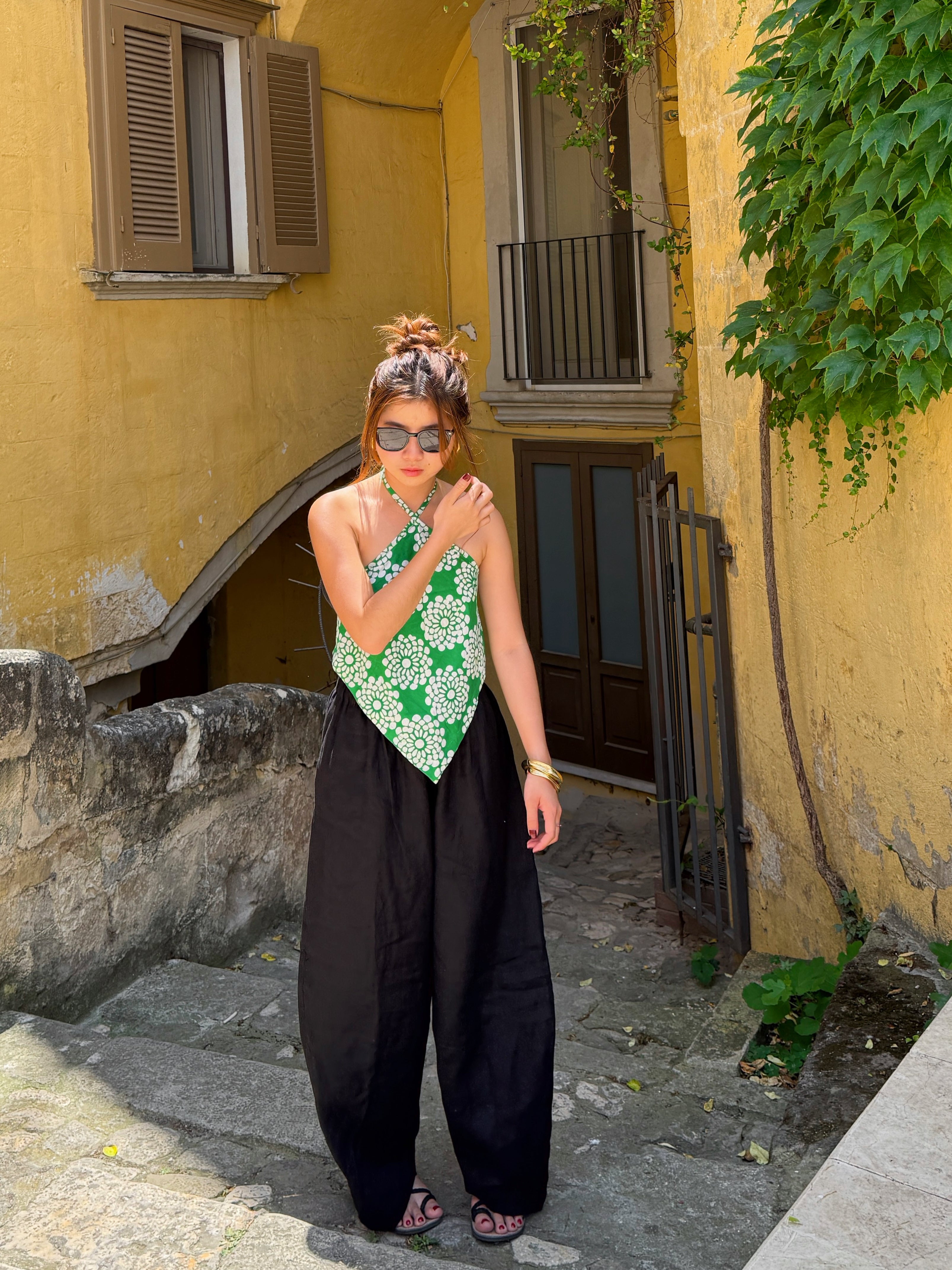 Model wearing green tropical flower batik halter crop top – handmade boho beachwear.