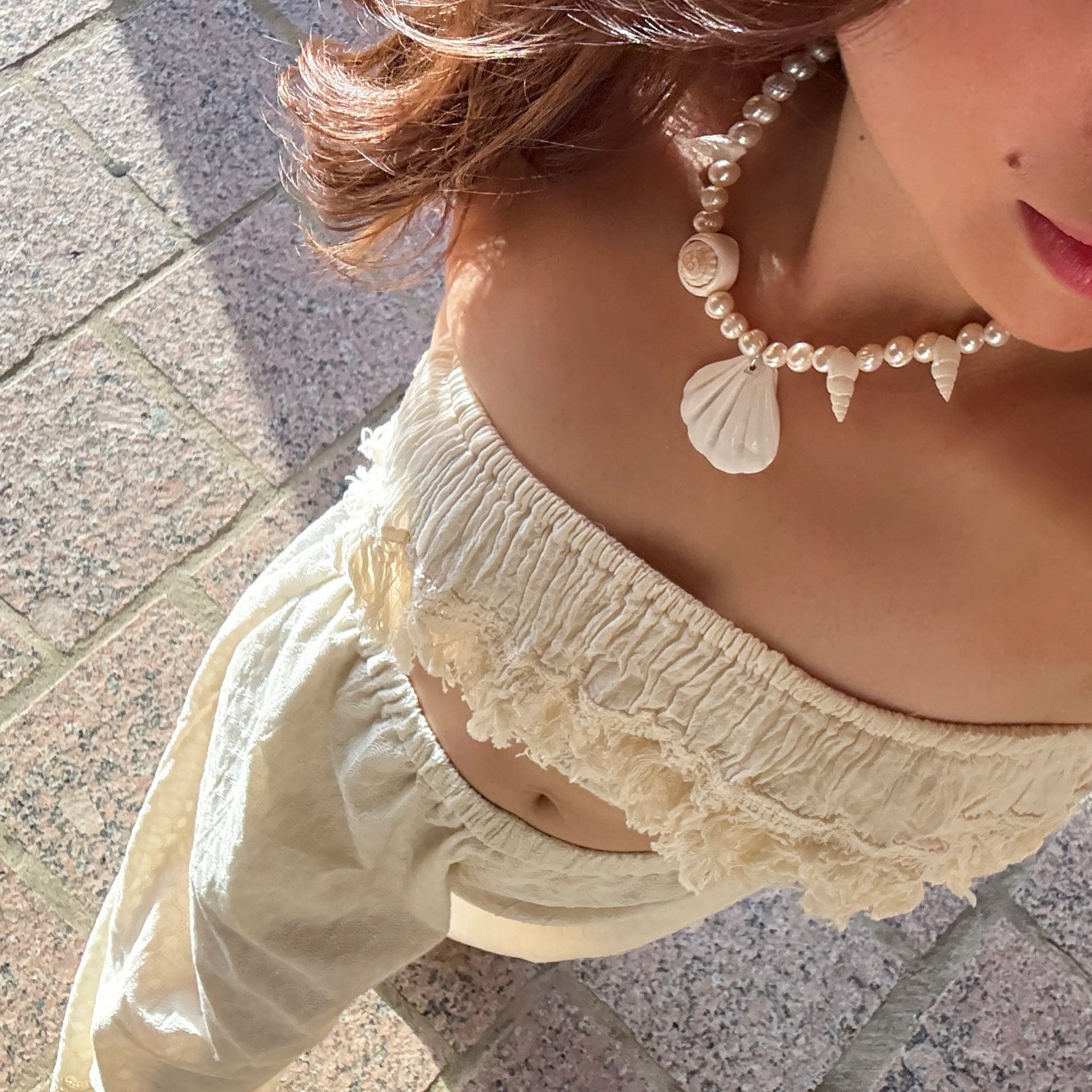 Model wearing the handmade Statement Seashell Pearl Choker, featuring natural freshwater pearls, real seashells, and tribal silver closure—styled as coastal boho jewelry, perfect for beach weddings, honeymoons, and resort wear.