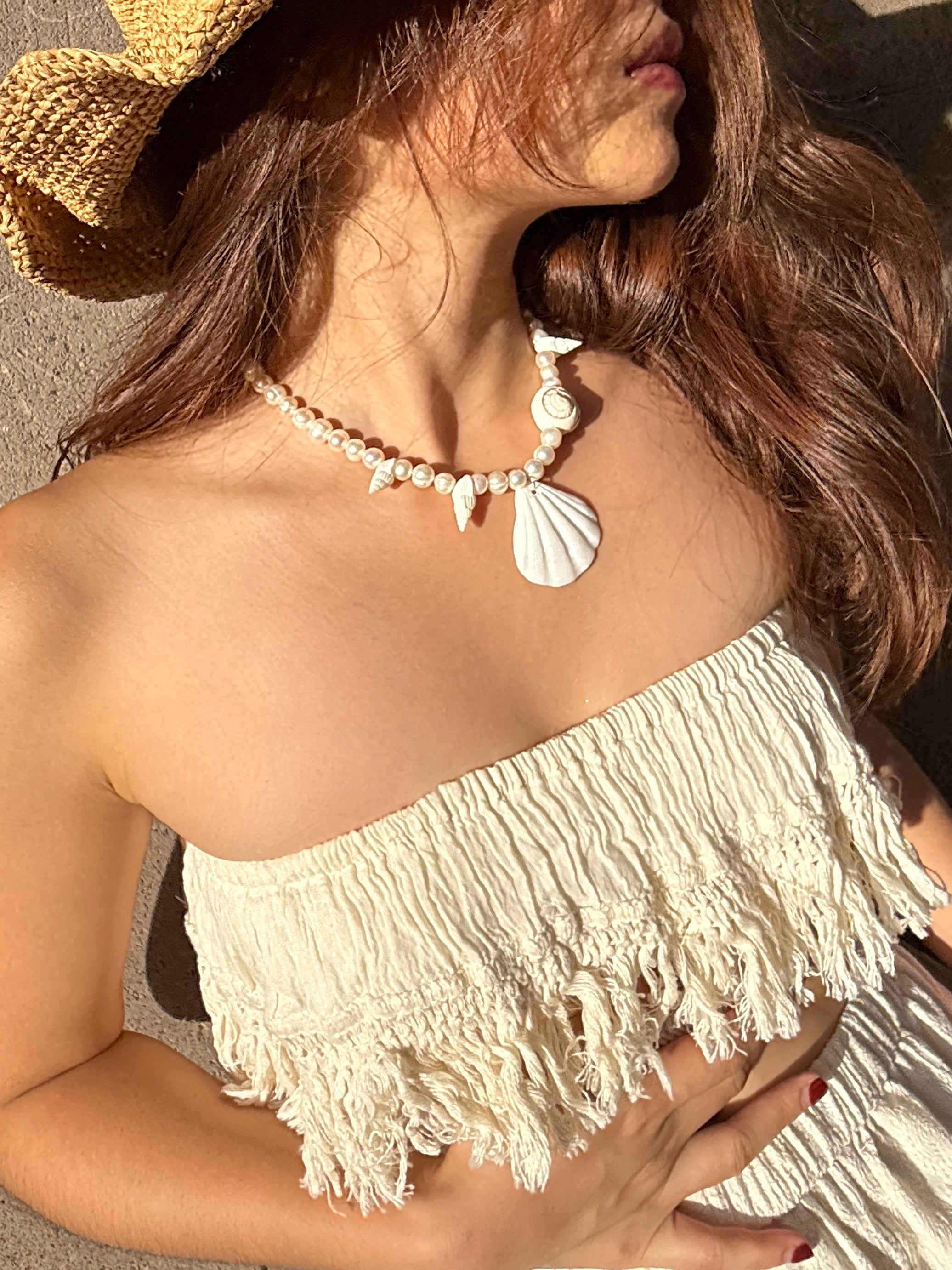 Model wearing white cotton lace fringe tube top with boho pants, posing outdoors in natural sunlight – handmade resortwear outfit