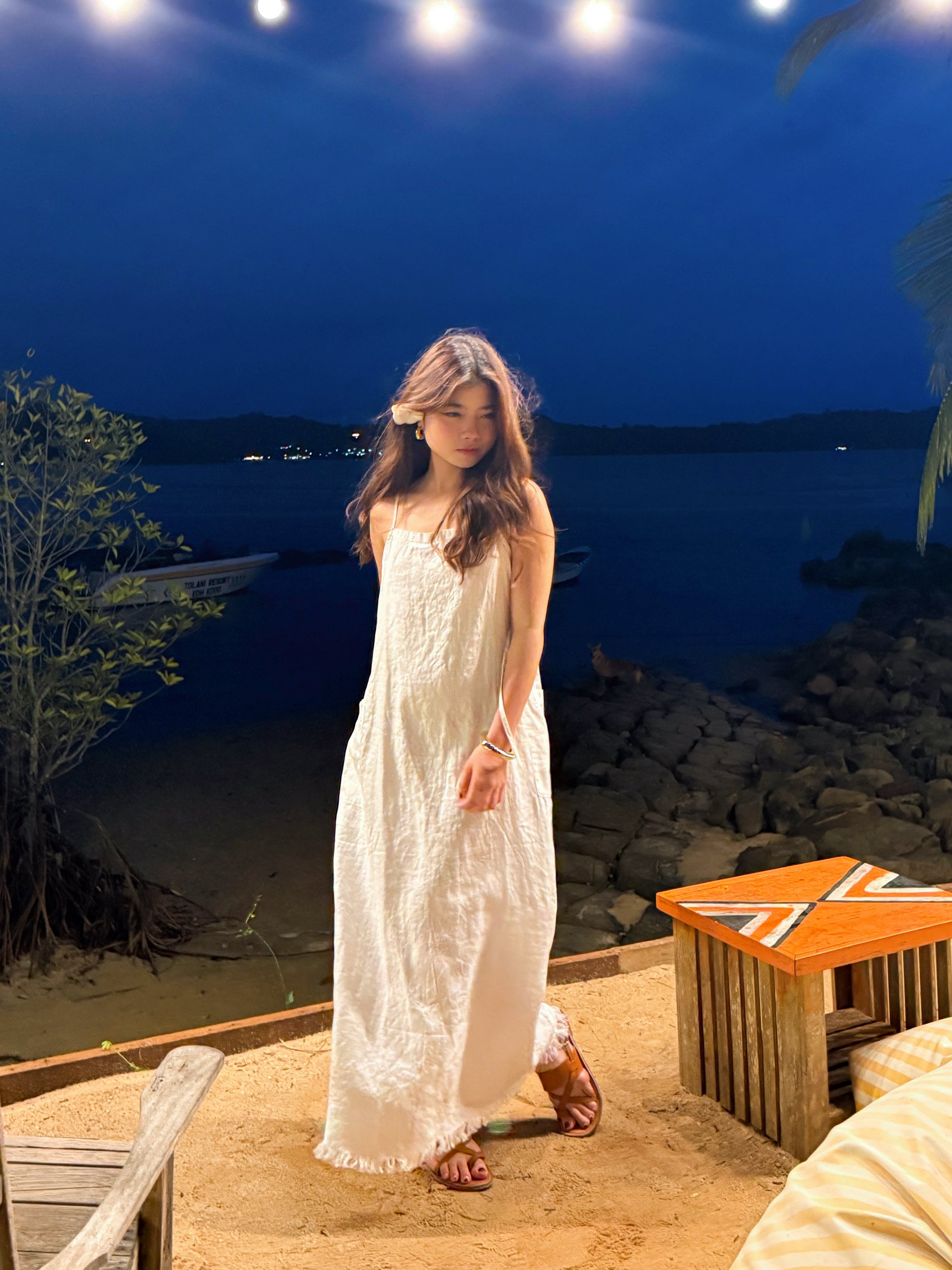 Model wearing white linen slip dress on the beach – minimalist summer look with natural linen fabric- perfect white dress for summer.