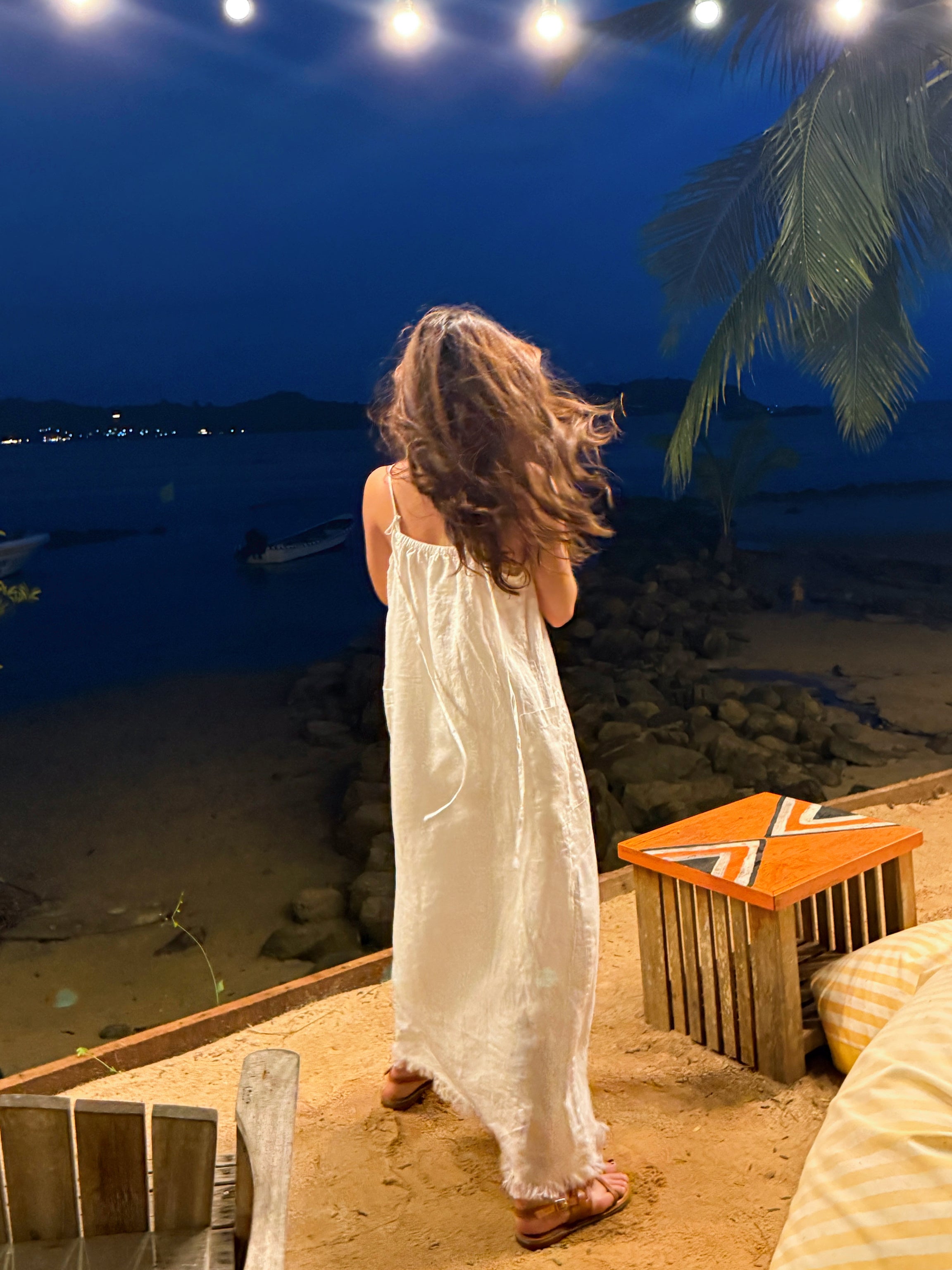 Model dancing in white linen slip dress on the beach – minimalist summer look with natural linen fabric- perfect white dress for summer – eco-friendly summer wardrobe essential