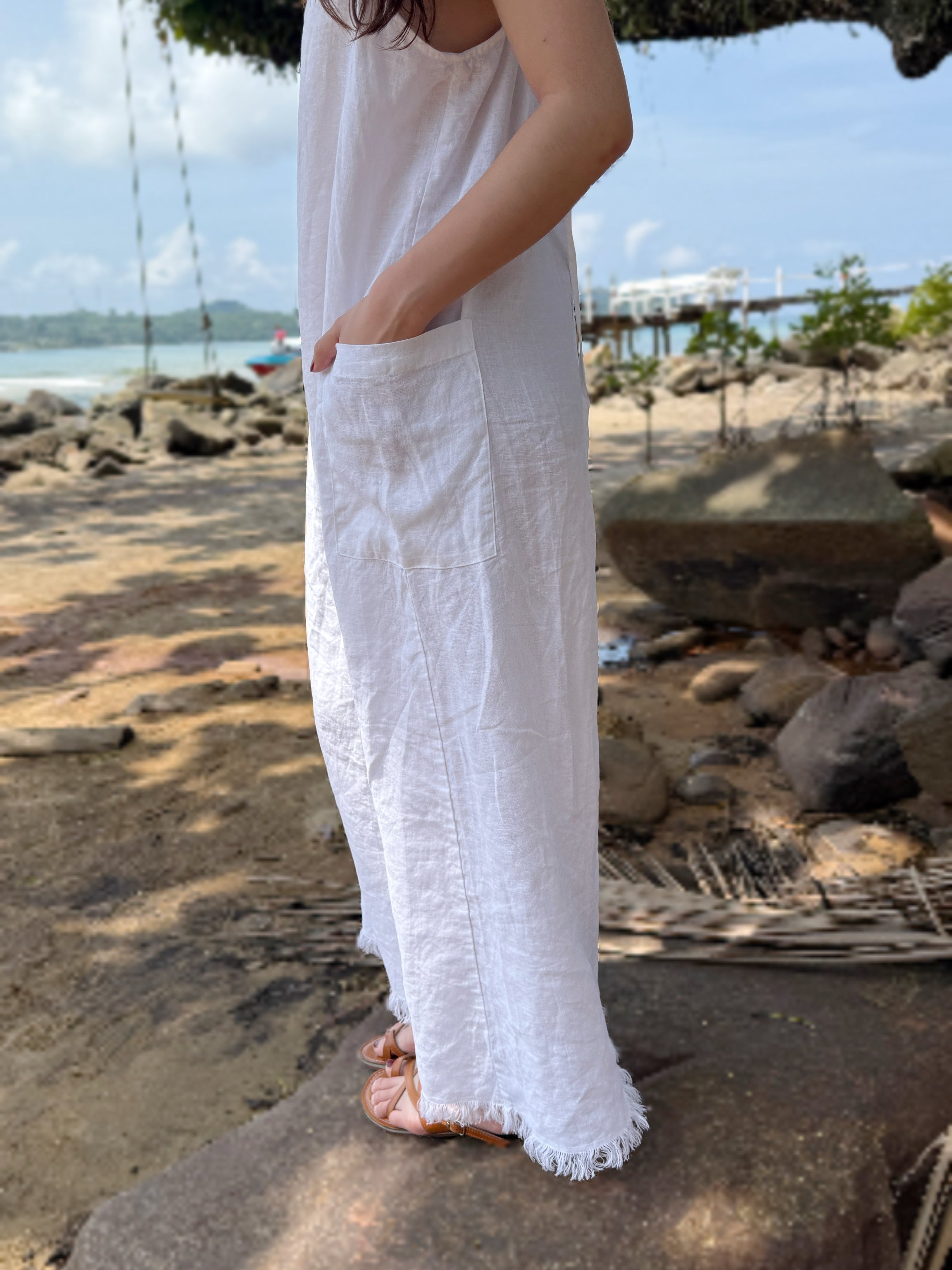 Model wearing in white linen slip dress on the beach – minimalist summer look with natural linen fabric- perfect white dress for summer – eco-friendly summer wardrobe essential