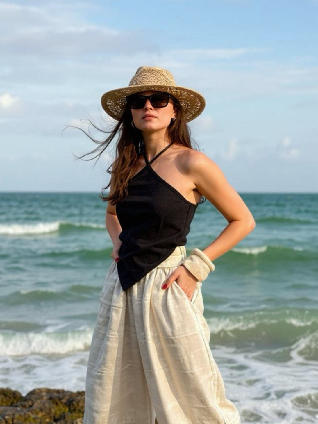 Model wearing natural hemp handkerchief halter crop top – sustainable boho festival and beach vacation outfit.