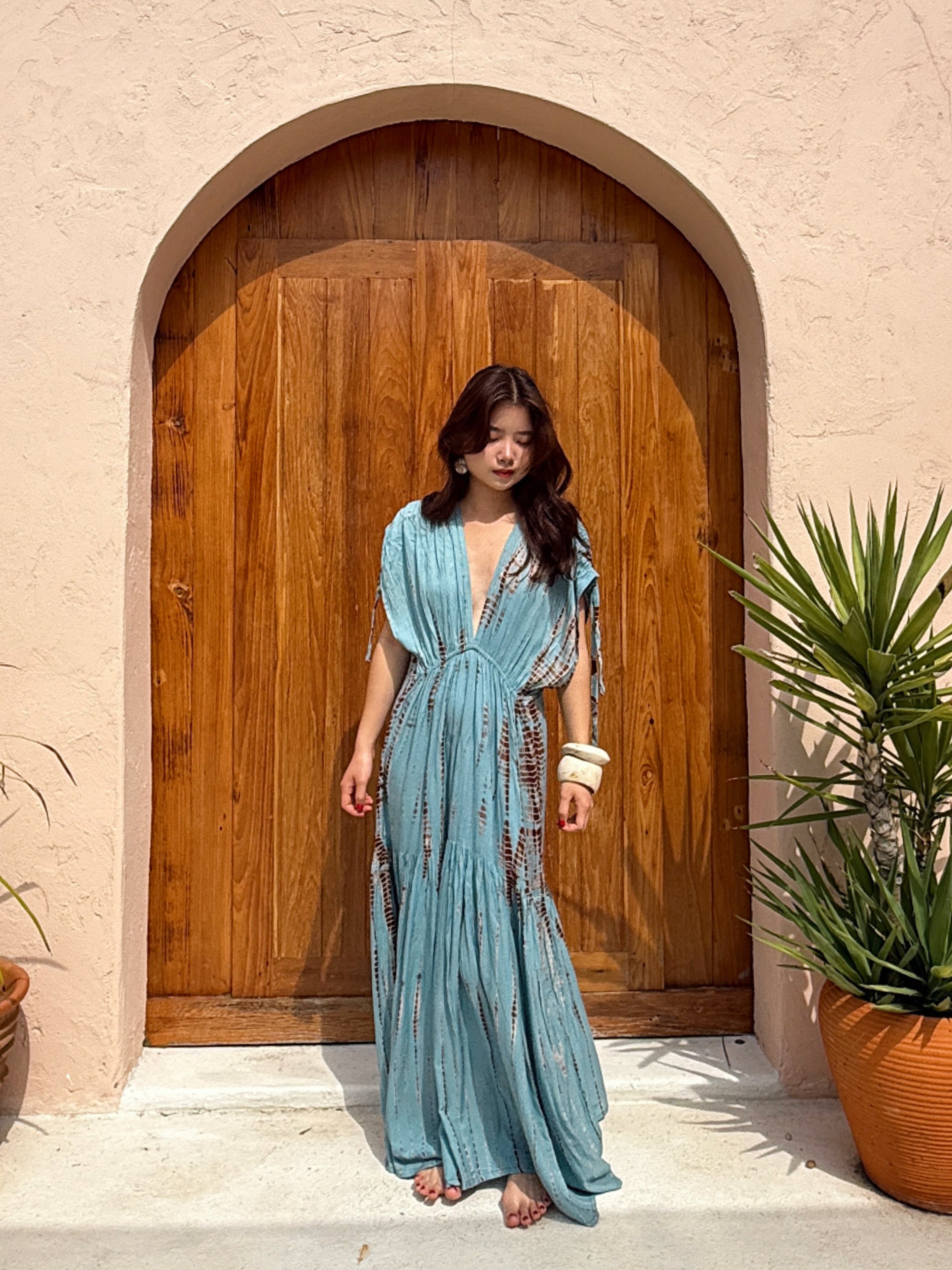Woman wearing the handmade Athena Goddess Kaftan Dress in teal—flowy tie-dye maxi dress with pockets, deep V-neckline, perfect for summer, resort wear, or festivals.