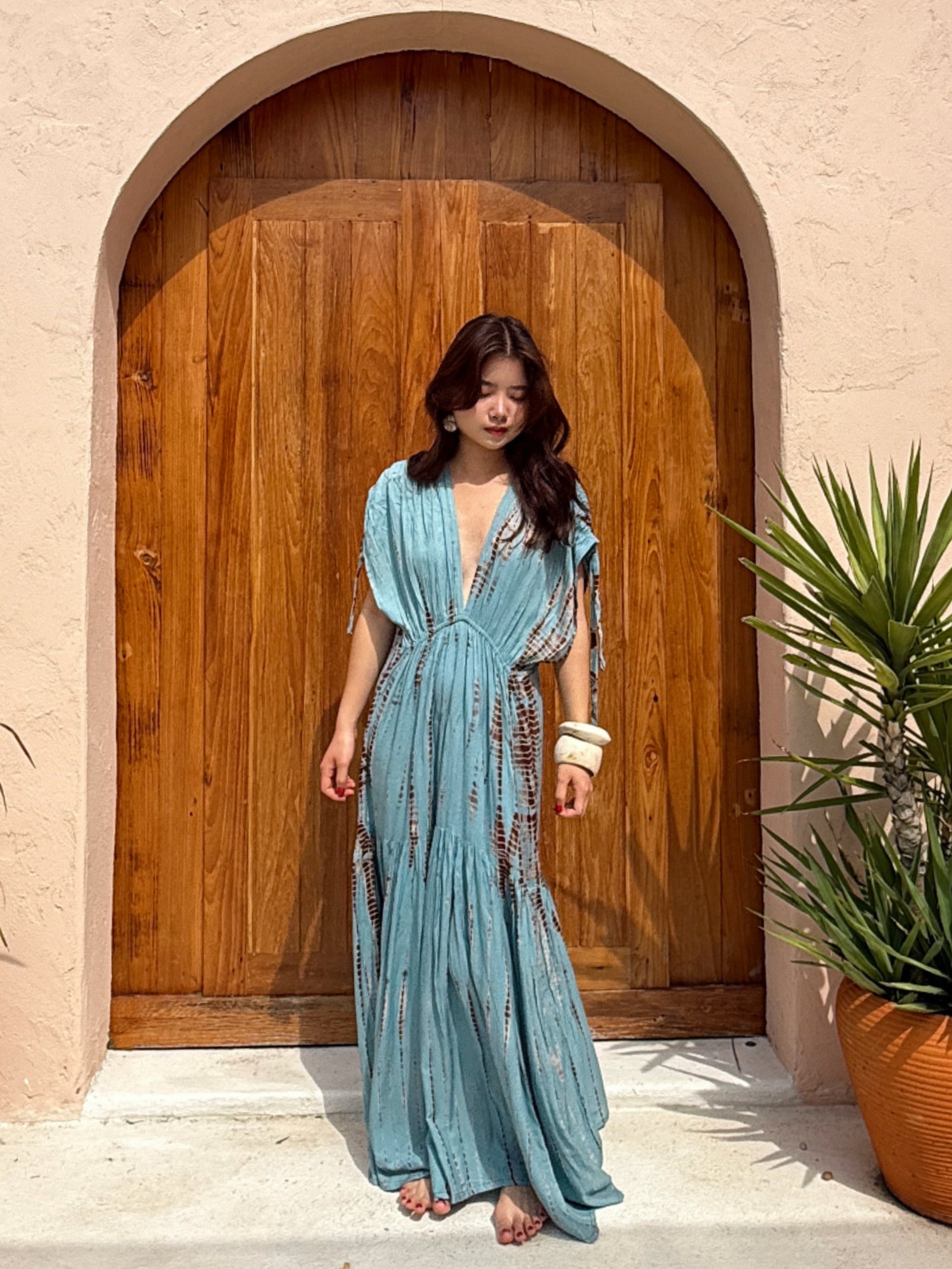 Woman wearing the handmade Athena Goddess Kaftan Dress in teal—flowy tie-dye maxi dress with pockets, deep V-neckline, perfect for summer, resort wear, or festivals.