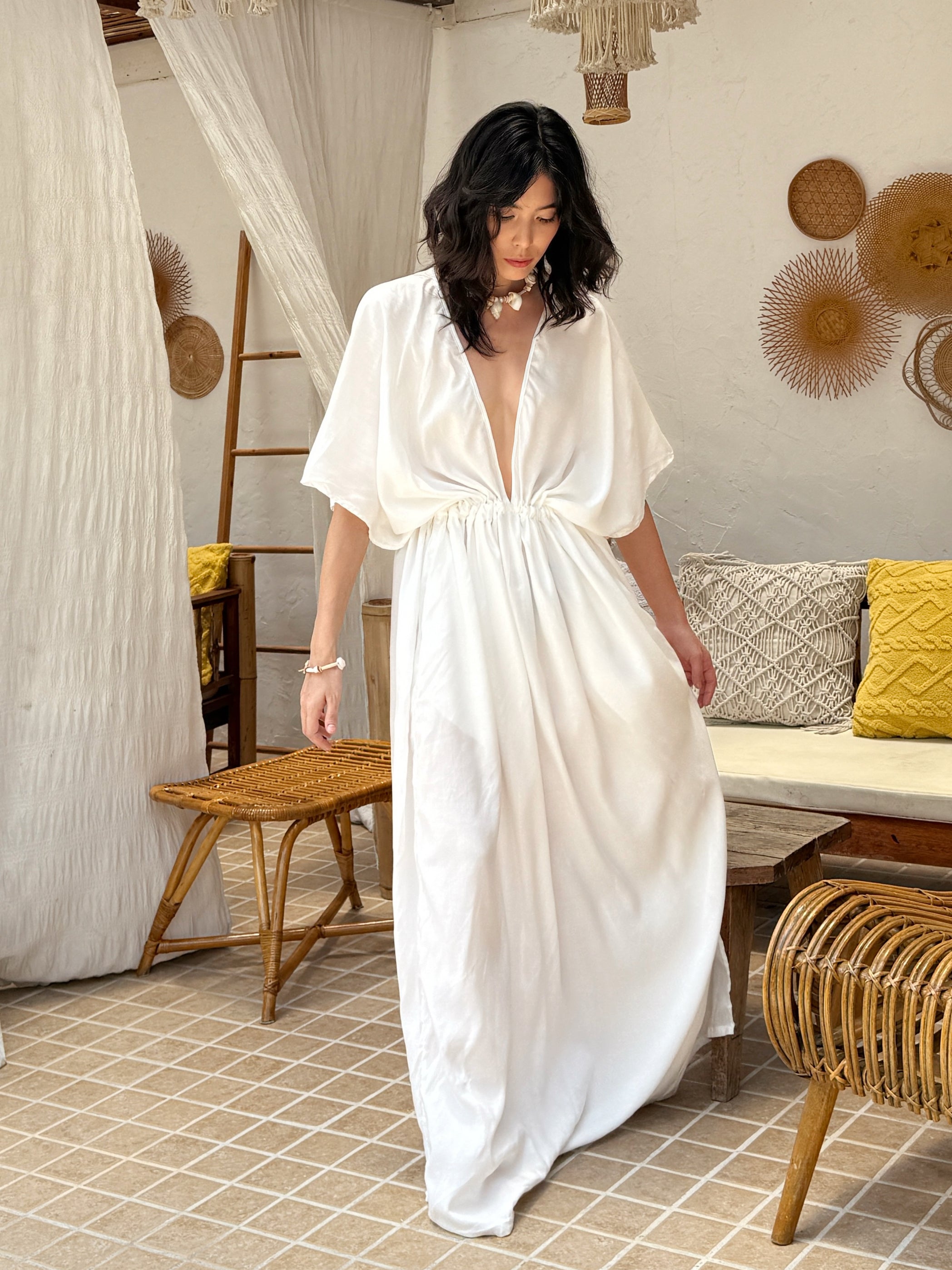 Model wearing a long white kaftan maxi dress with a flowing silhouette—styled as a beach outfit, resort wear, or elegant boho cover-up.