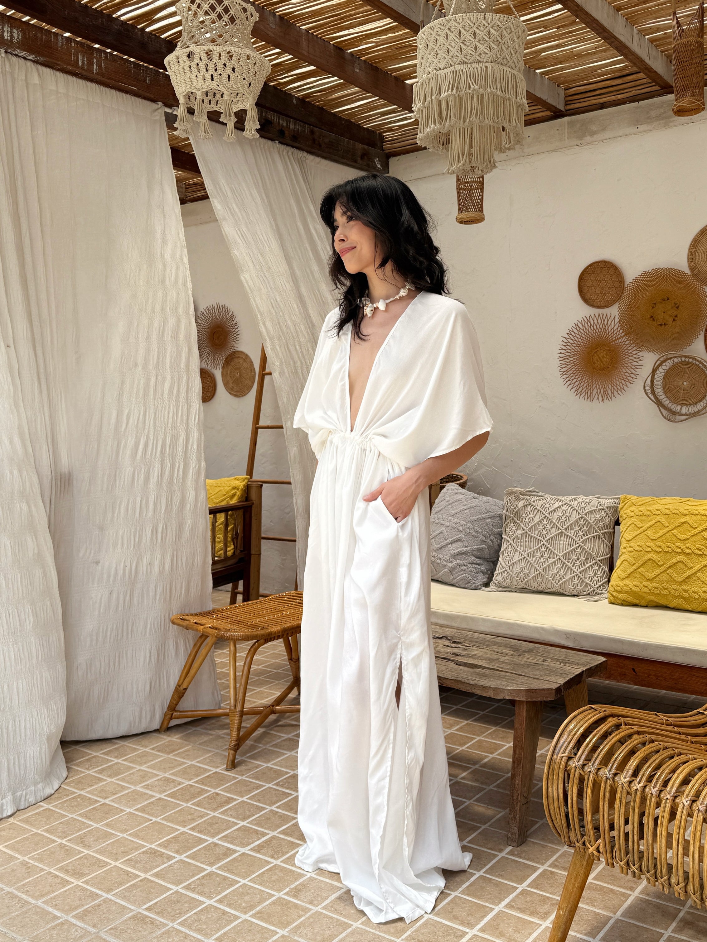 Model wearing a long white kaftan maxi dress with a flowing silhouette—styled as a beach outfit, resort wear, or elegant boho cover-up.