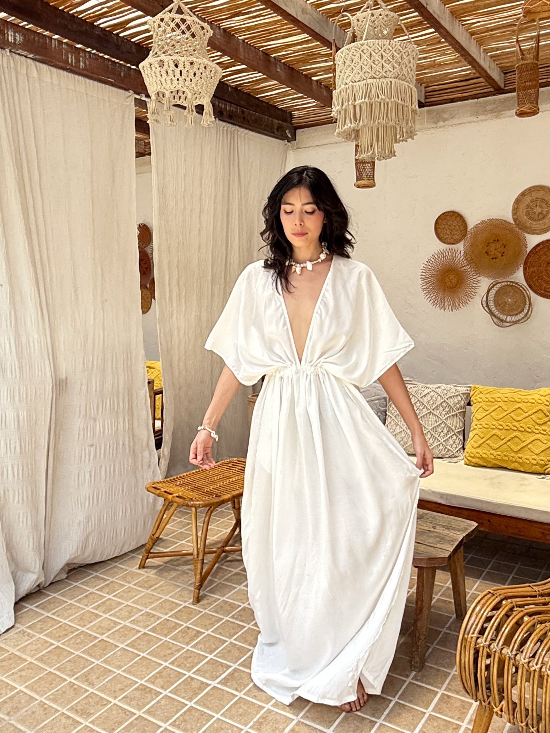 Model wearing a long white kaftan maxi dress with a flowing silhouette—styled as a beach outfit, resort wear, or elegant boho cover-up.