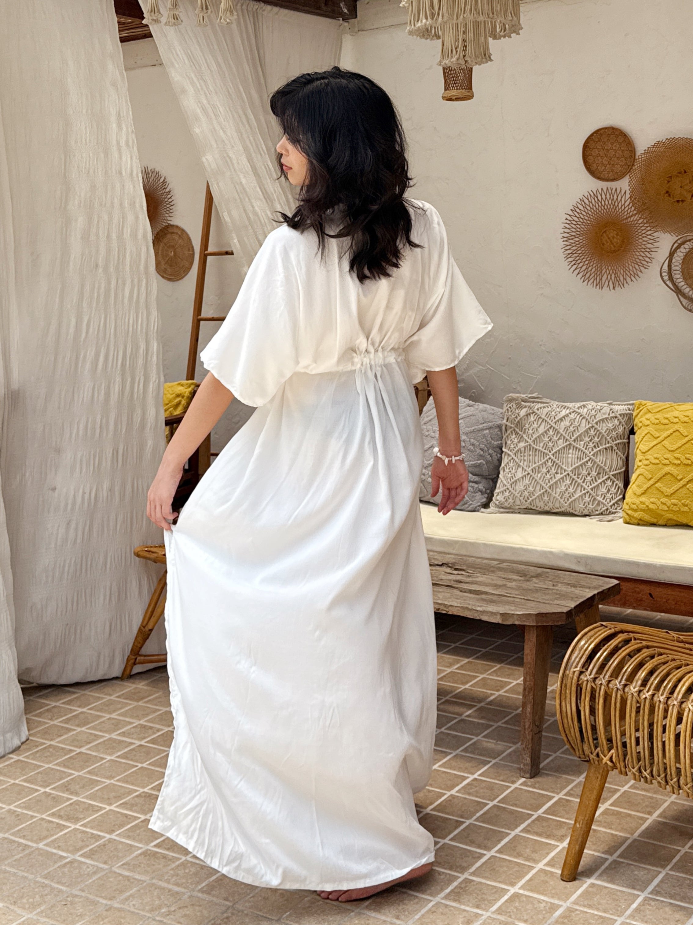 Model wearing a long white kaftan maxi dress with a flowing silhouette—styled as a beach outfit, resort wear, or elegant boho cover-up.