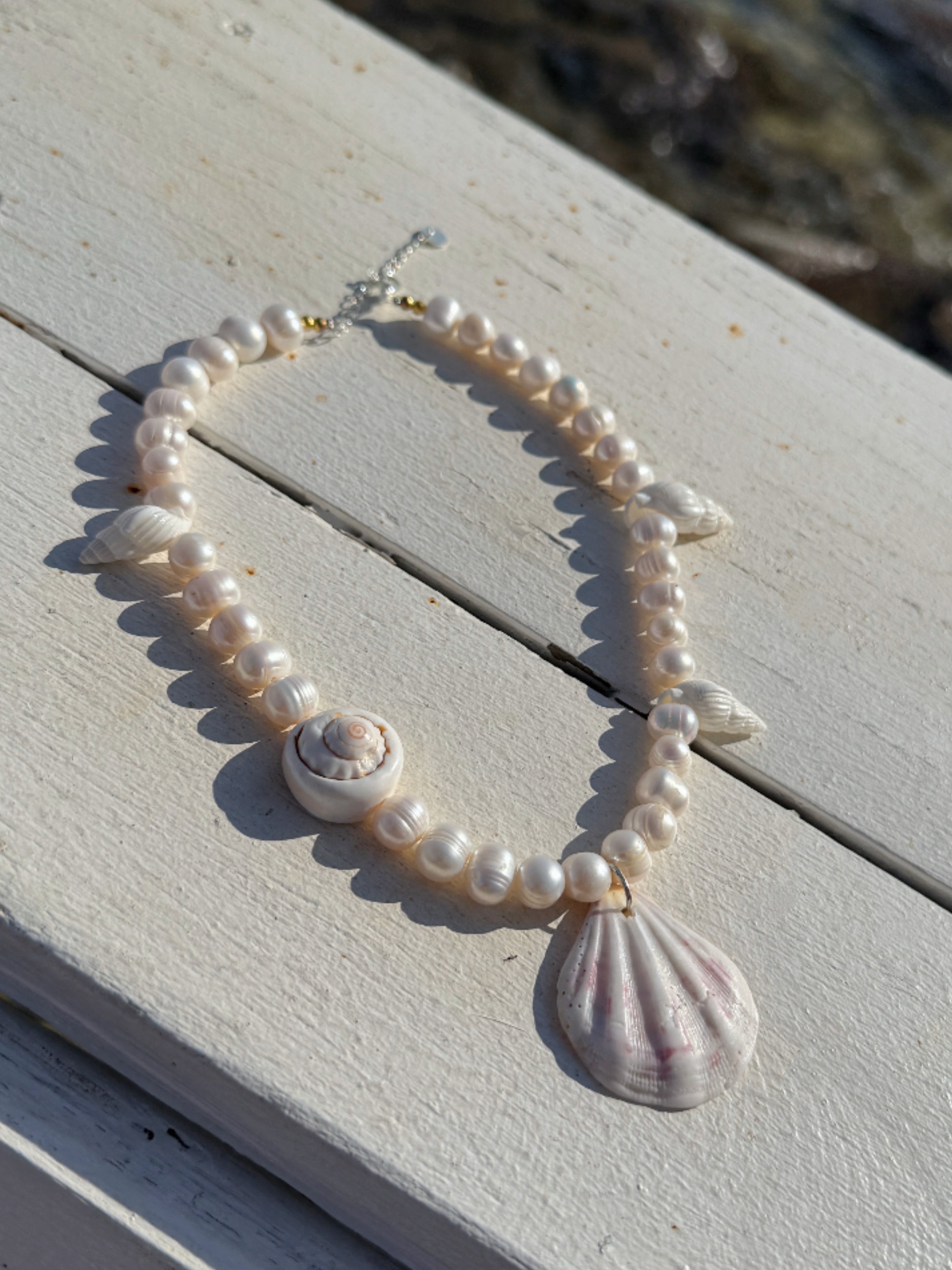 Model wearing the handmade Statement Seashell Pearl Choker, featuring natural freshwater pearls, real seashells, and tribal silver closure—styled as coastal boho jewelry, perfect for beach weddings, honeymoons, and resort wear.