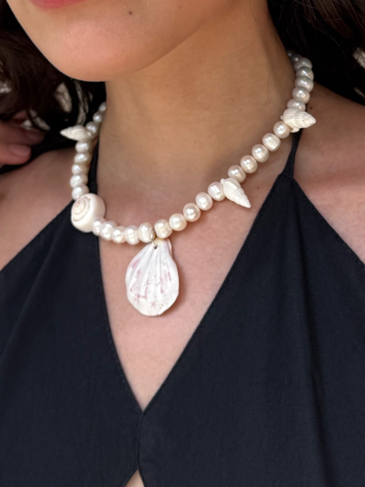 Model wearing the handmade Statement Seashell Pearl Choker, featuring natural freshwater pearls, real seashells, and tribal silver closure—styled as coastal boho jewelry, perfect for beach weddings, honeymoons, and resort wear.
