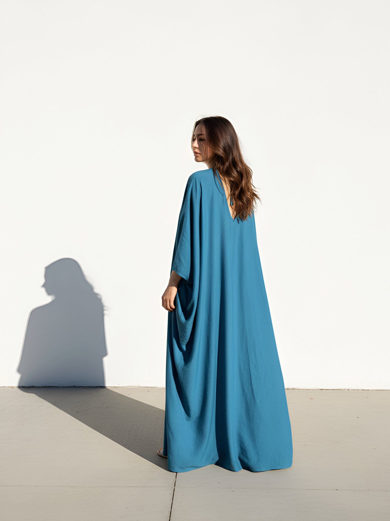 Woman wearing a teal blue Kaftan maxi dress, resort caftan maxi dress, beach cover up with relaxed sleeves and elegant drape—perfect for pool, beach, and cruise