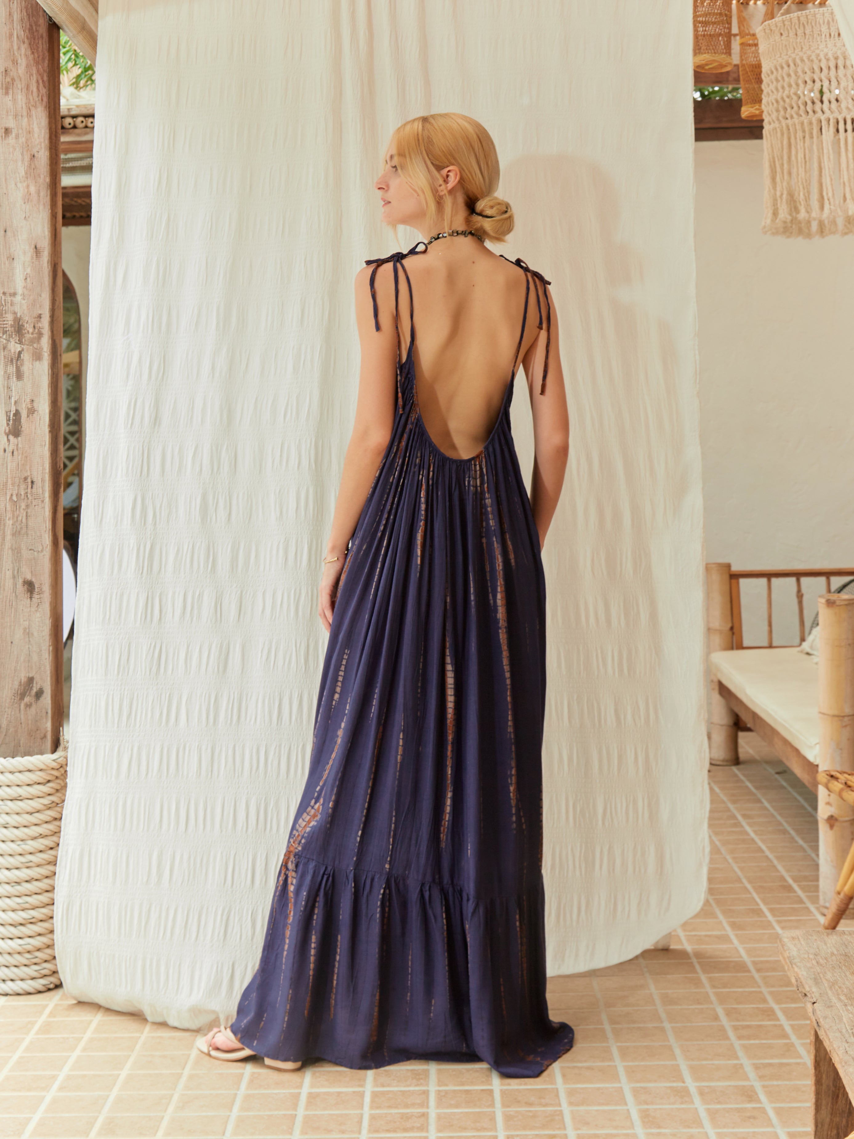 Oversized boho tie-dye maxi dress with open back, ruffle hem detailing, and adjustable tie-shoulder design for beach or resort wear.