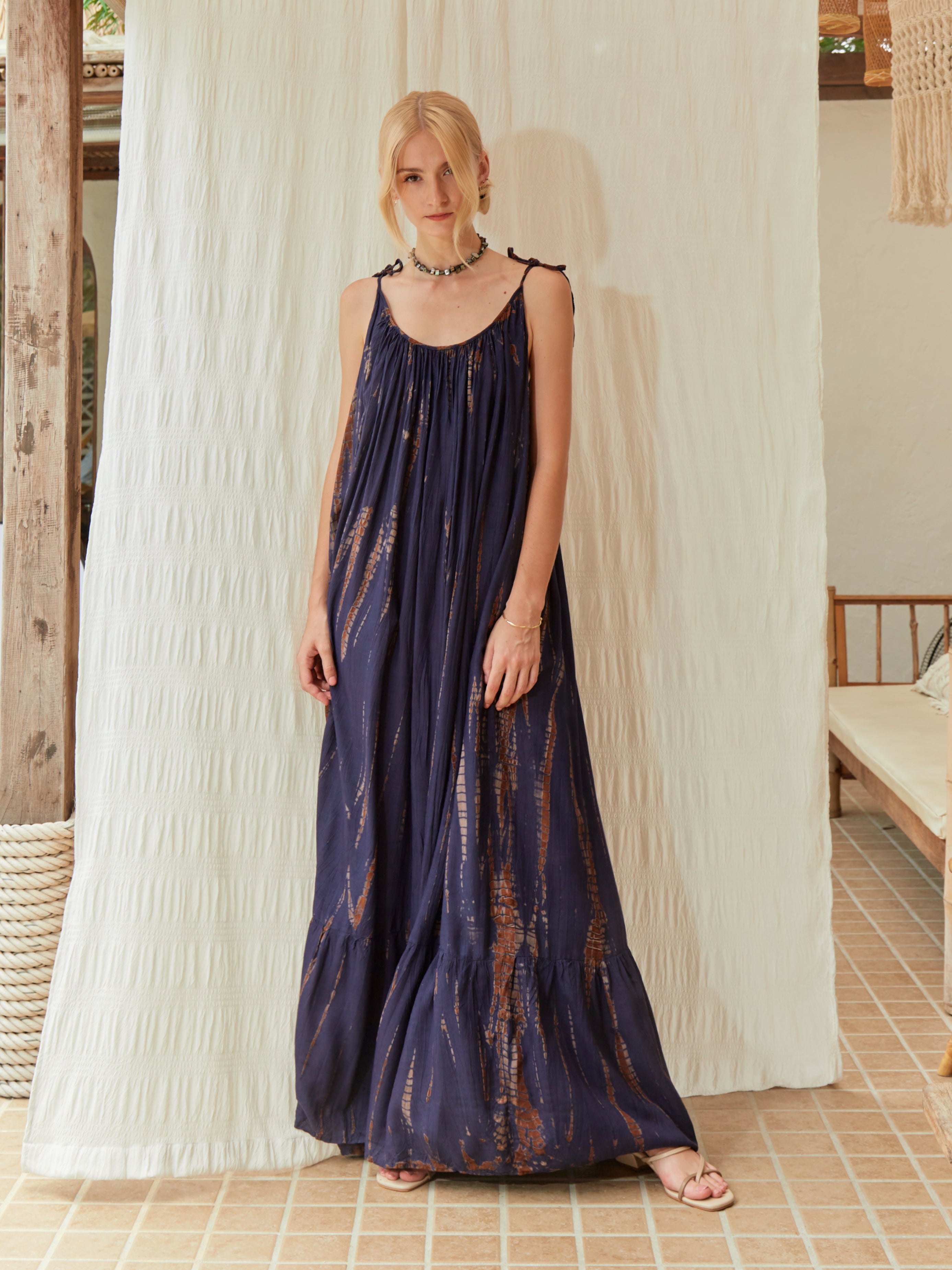 Model wearing a handmade tie-dye maxi dress with deep v-neckline and open back, styled for vacation and summer events.