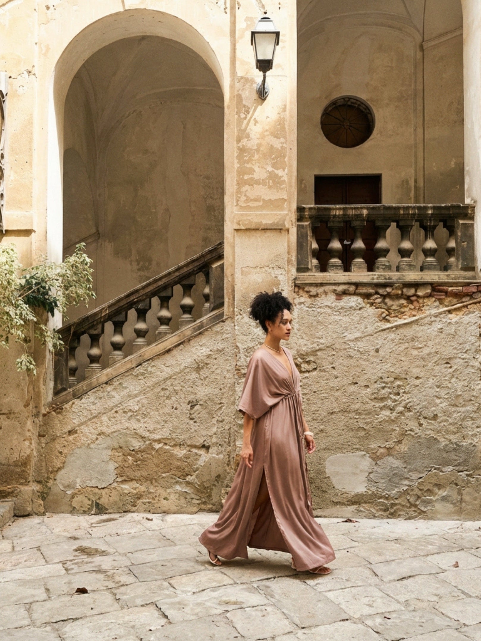 Woman wearing a mocha rose kaftan maxi dress with deep V-neck and self-tie waist, styled as resort wear and a beach wedding guest dress