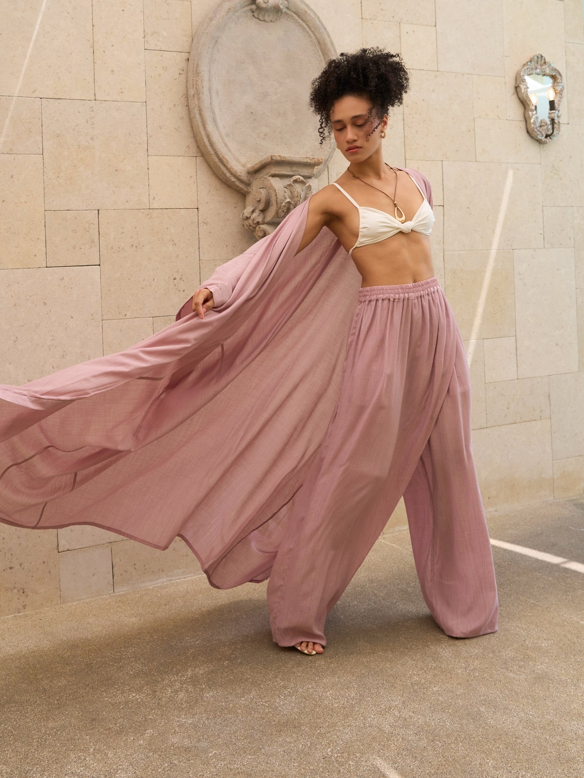 Woman wearing oversized mauve kimono kaftan as lightweight resort cover up, styled for beach and vacation wear by COCO DE CHOM