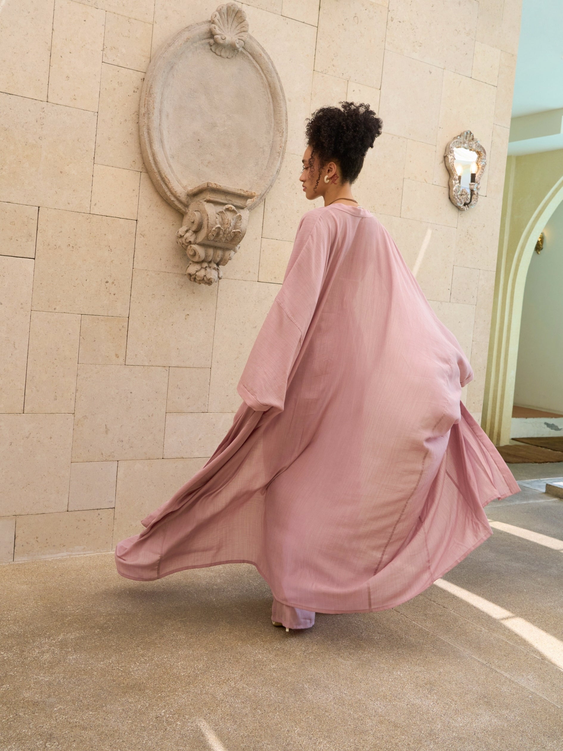 Woman wearing oversized mauve kimono kaftan as lightweight resort cover up, styled for beach and vacation wear by COCO DE CHOM