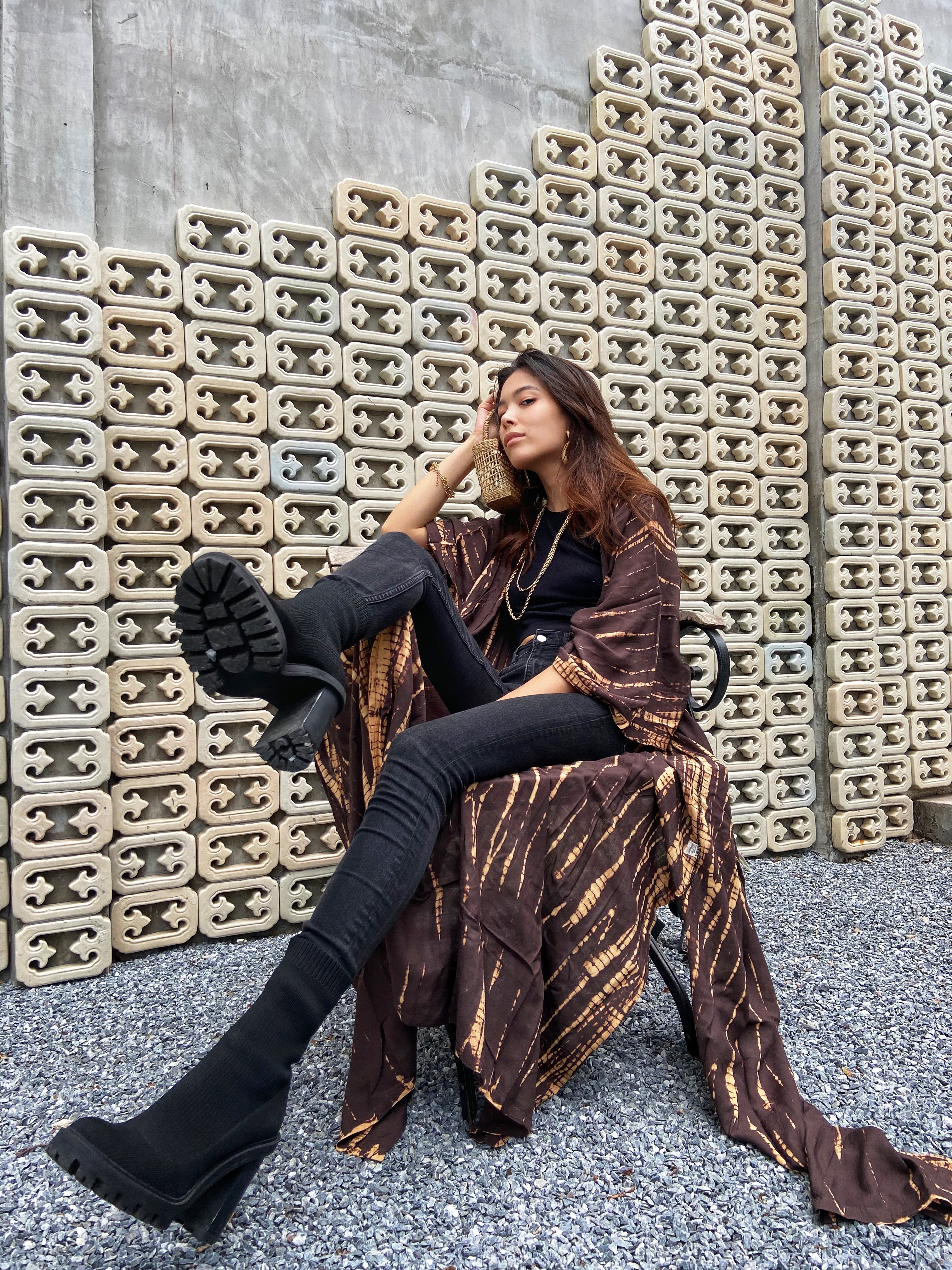 Woman lounging in oversized boho tie dye kimono robe in brown, relaxed vacation boho look