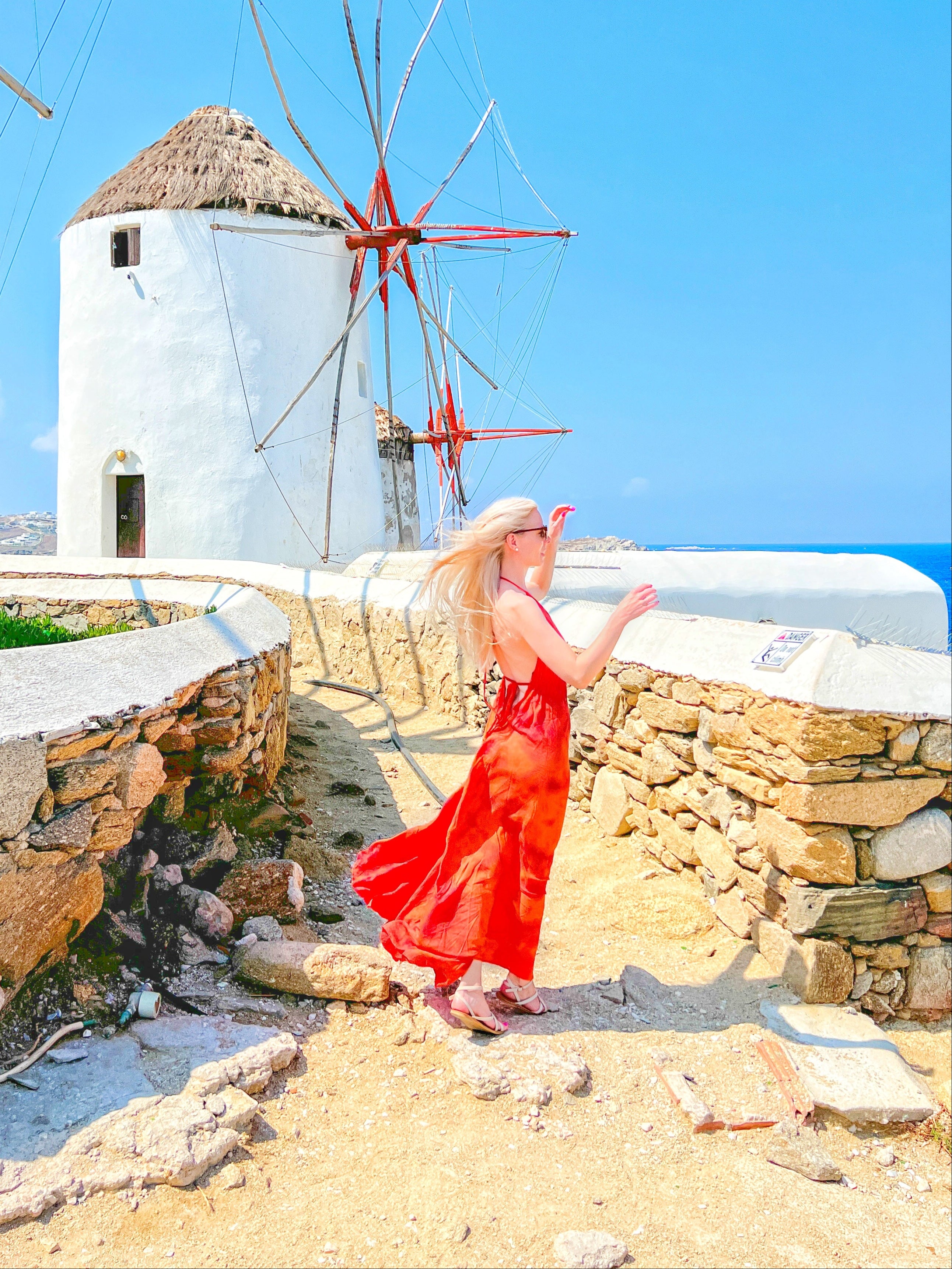 Woman wearing an orange tie-dye open Back Halter Maxi Dress in vibrant orange tie-dye, featuring a flowing maxi length and backless halter design—perfect vacation dress by Coco De Chom.