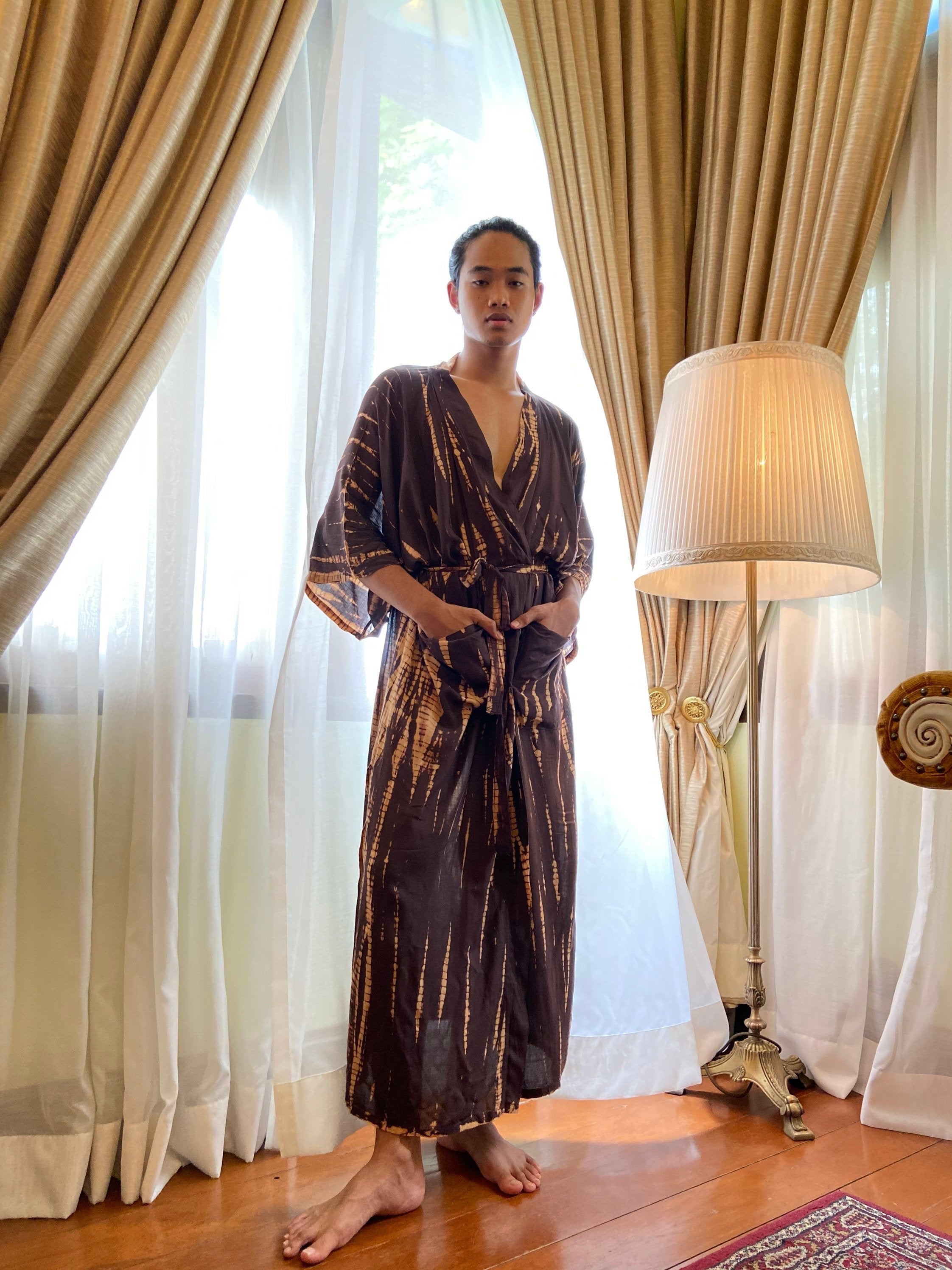 Man standing in tie dye kimono robe in brown, relaxed vacation boho look